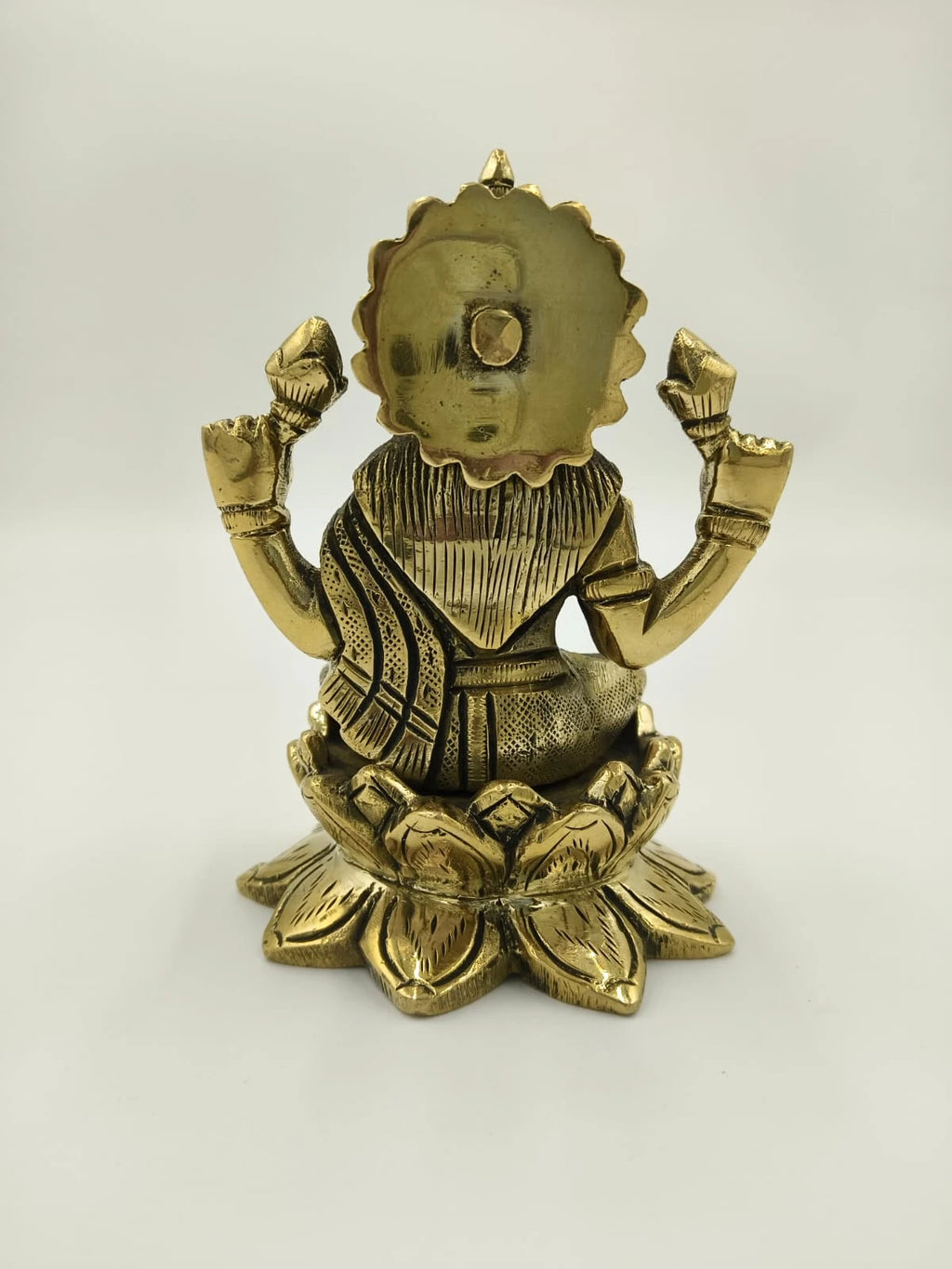 Back view of medium brass Lakshmi sculpture seated on lotus pedestal