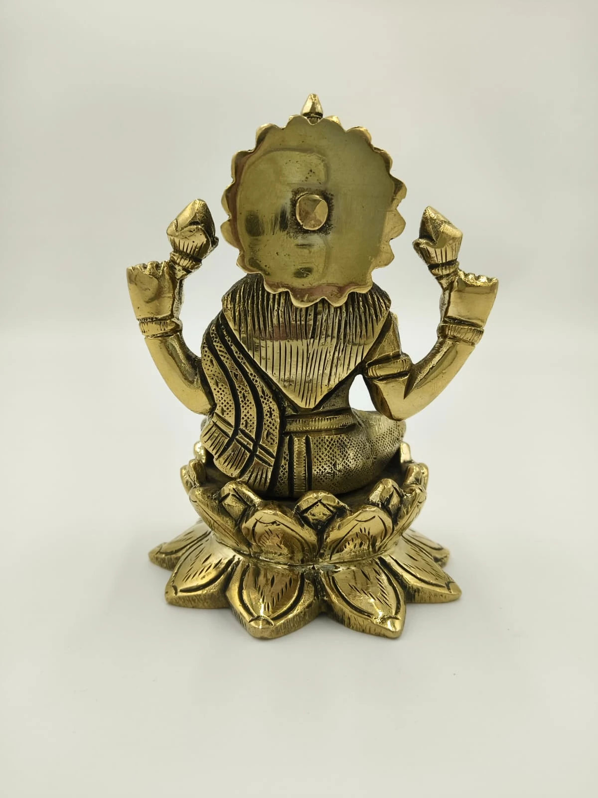 Back view of medium brass Lakshmi sculpture seated on lotus pedestal
