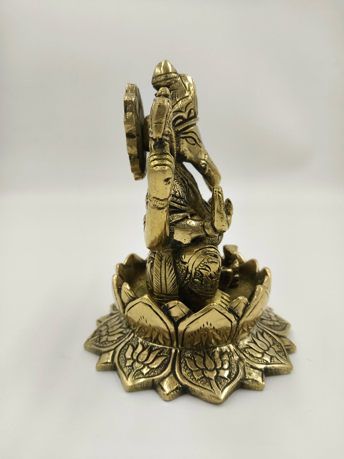 Side view of large brass Padma Hasta Ganapati statue on lotus base