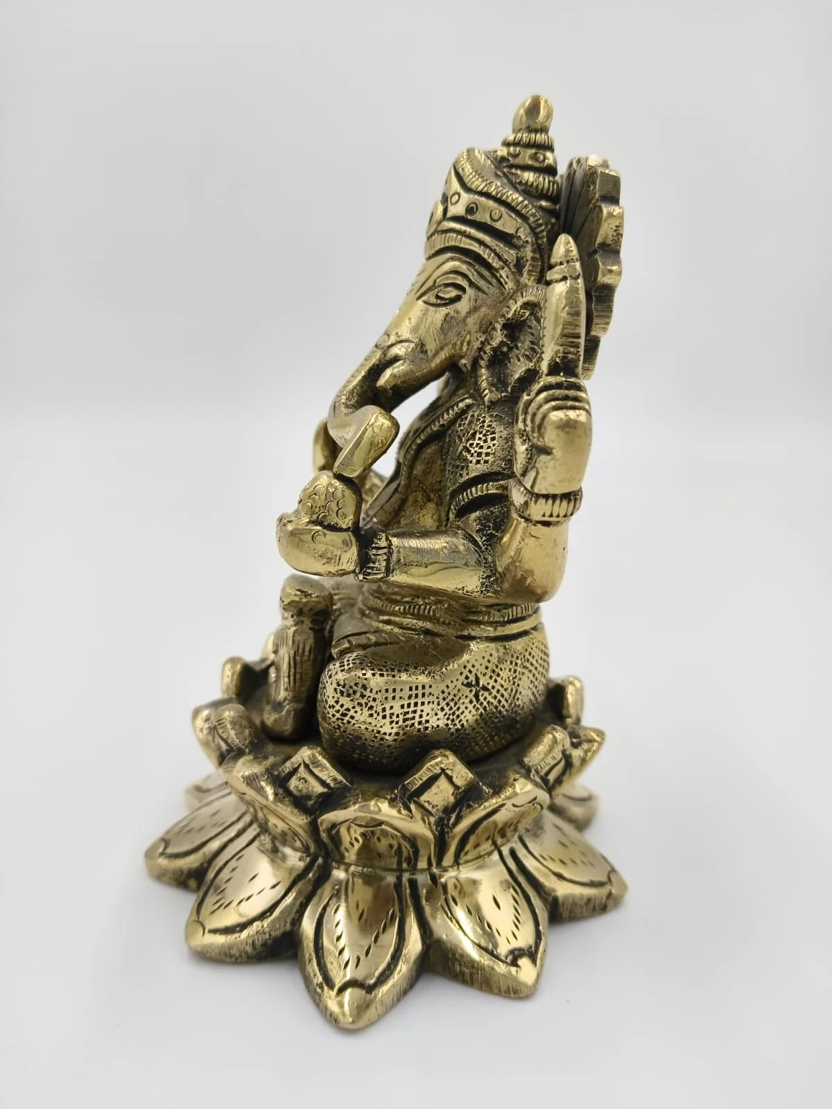 Brass statue of Padma Hasta Ganapati sitting on a lotus base side view