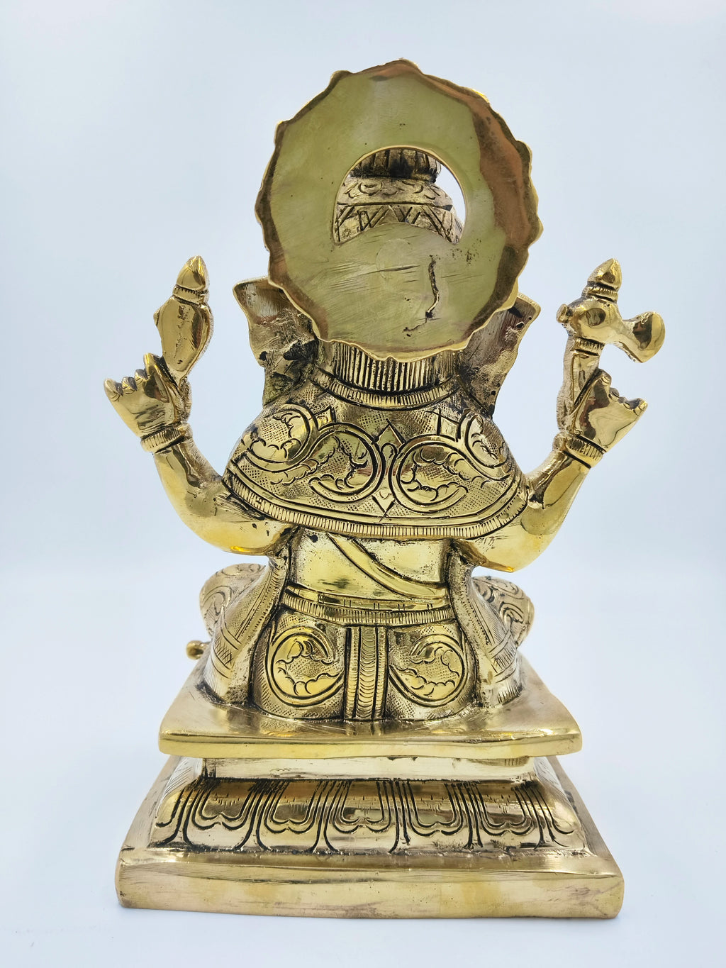 Back view of large brass Padmasana Ganapati statue with intricate detailing