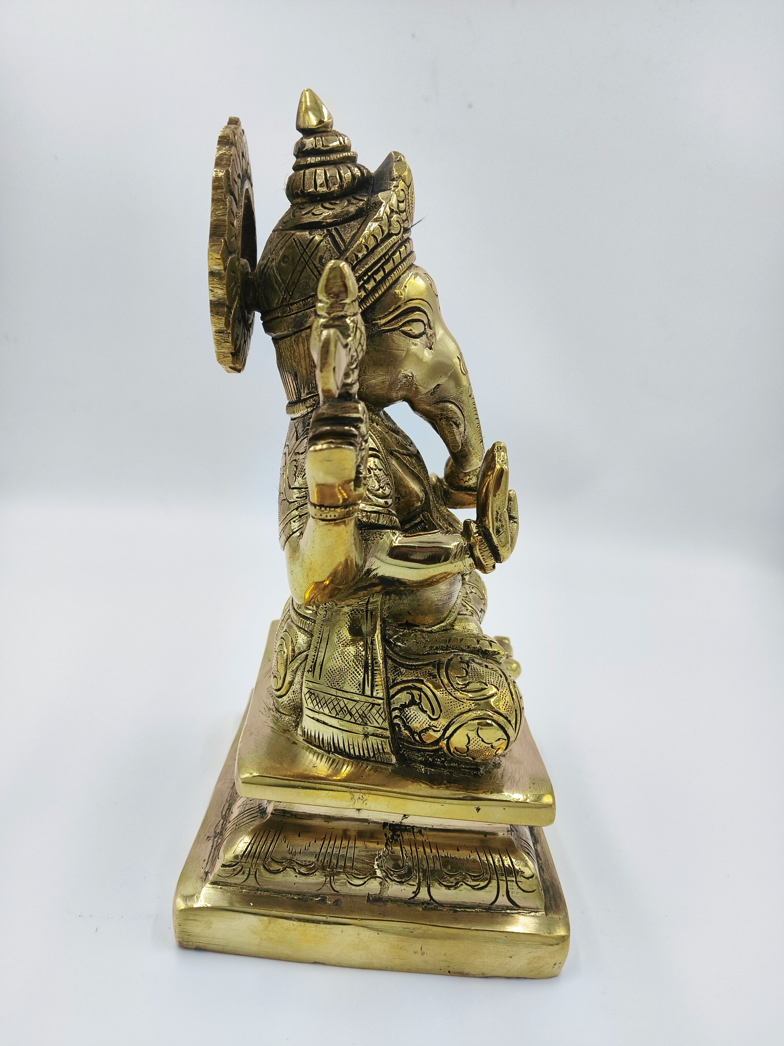 Side view of large brass Padmasana Ganapati statue with intricate detailing