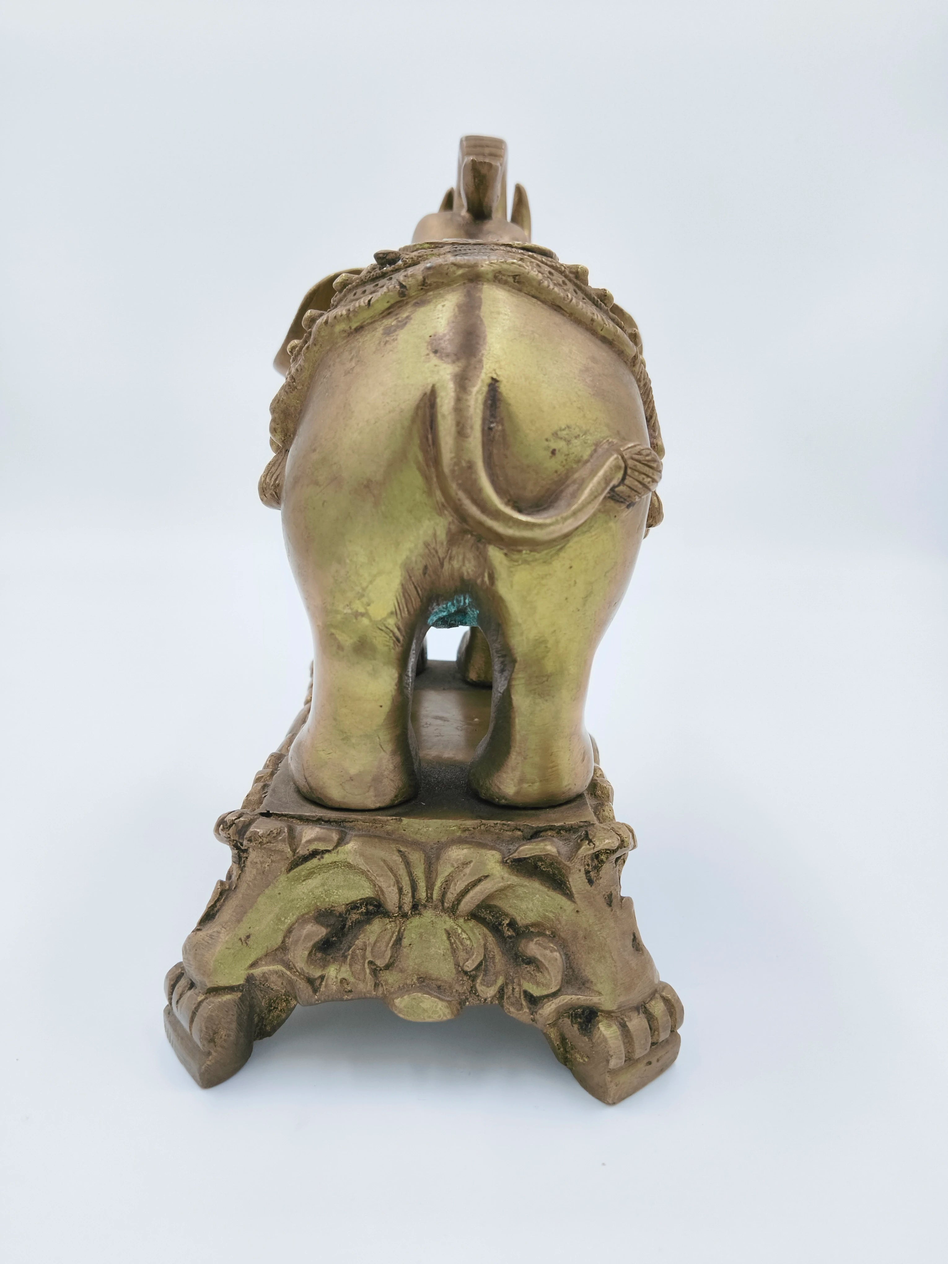 Rear view of large brass elephant sculpture on ornate base