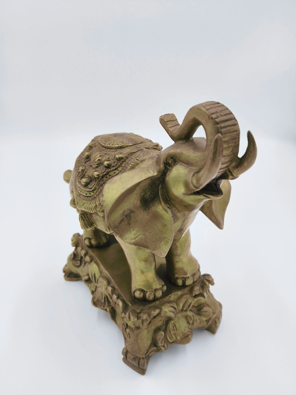 Brass elephant sculpture with intricate carvings on stand and body