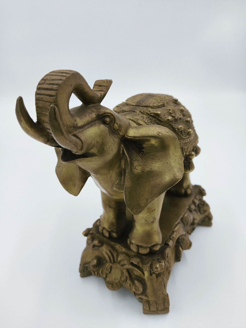 Decorative brass elephant sculpture with detailed carvings on base and back