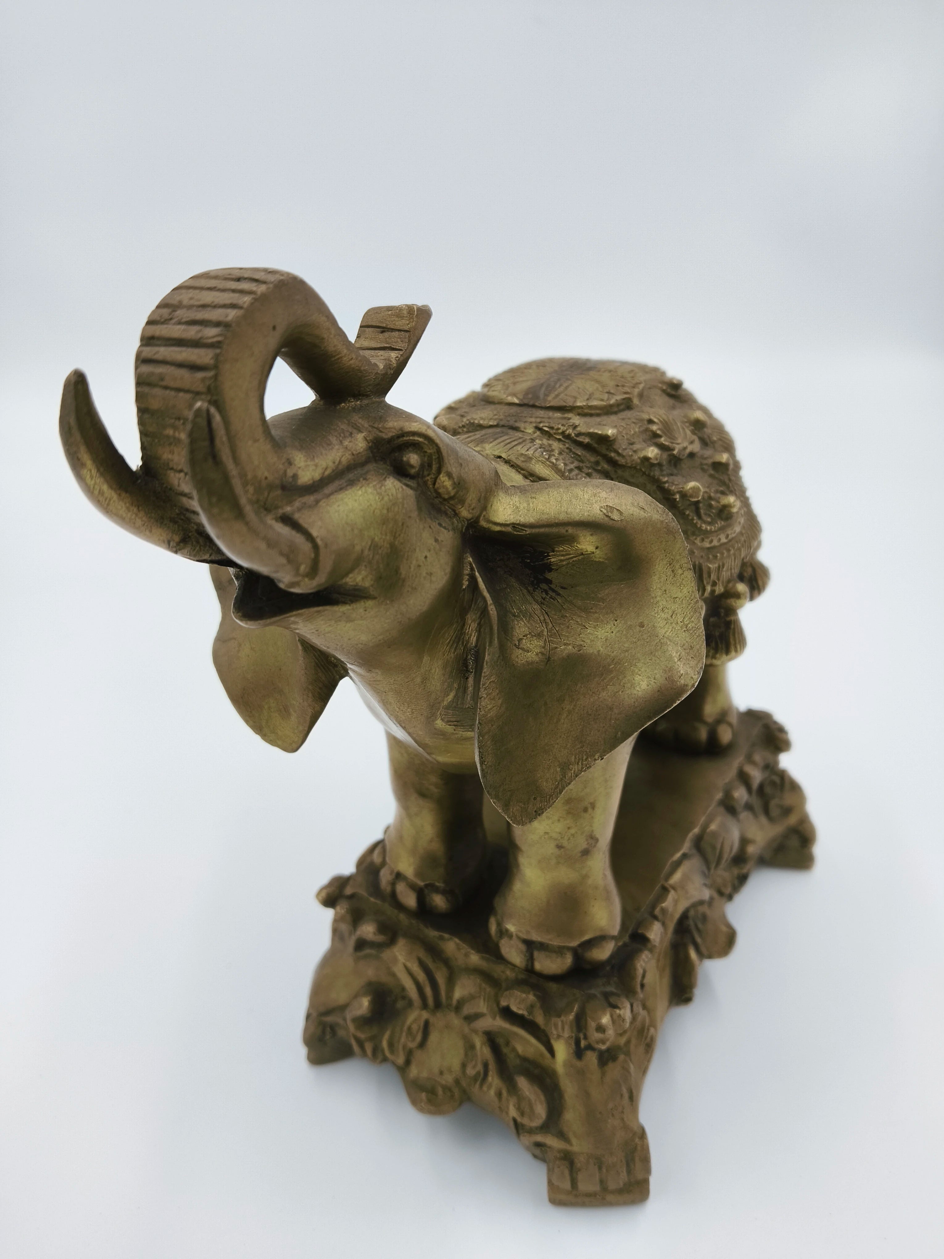 Decorative brass elephant sculpture with detailed carvings on base and back