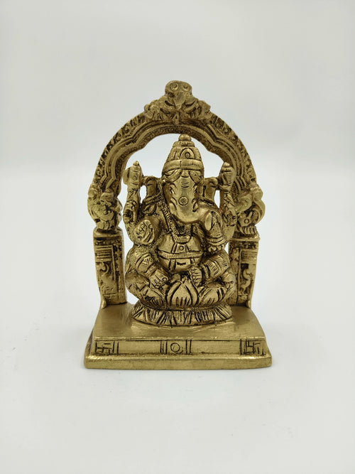 Small brass sculpture of Lord Ganesha seated with decorative arch on base