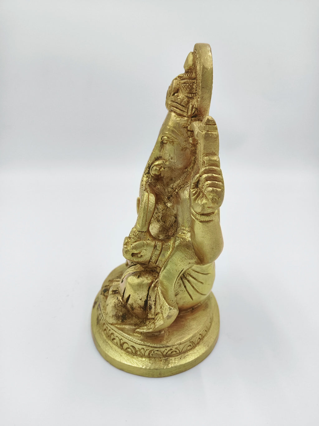 Side view of medium brass Padmasana Ganapati statue seated on a round base