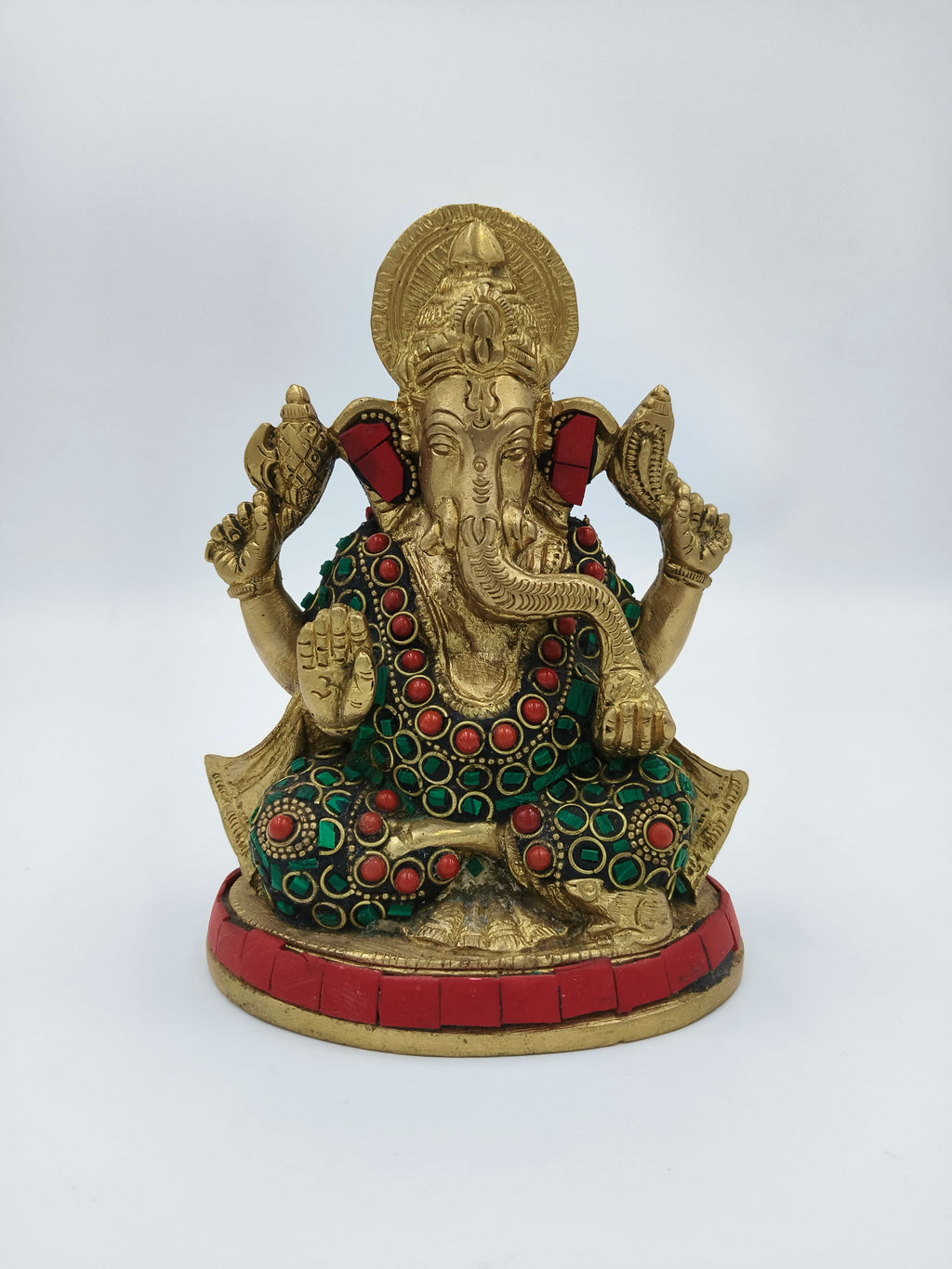 Front view of medium brass Ganesh sculpture with red and green embellishments