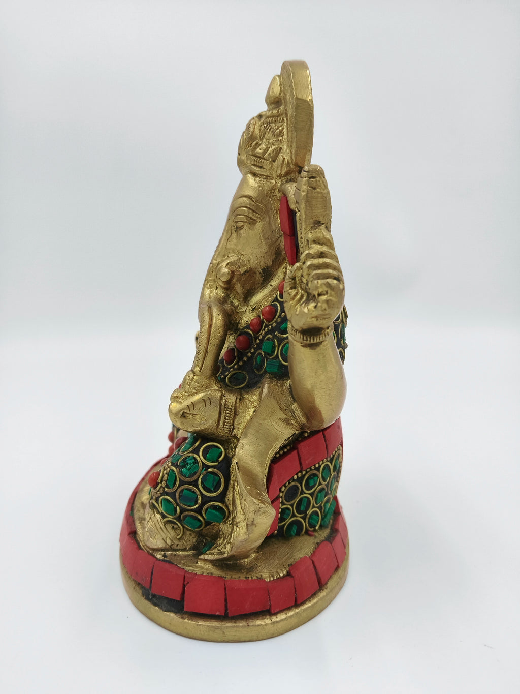 Side view of medium brass Ganesh statue with red and green inlay decoration