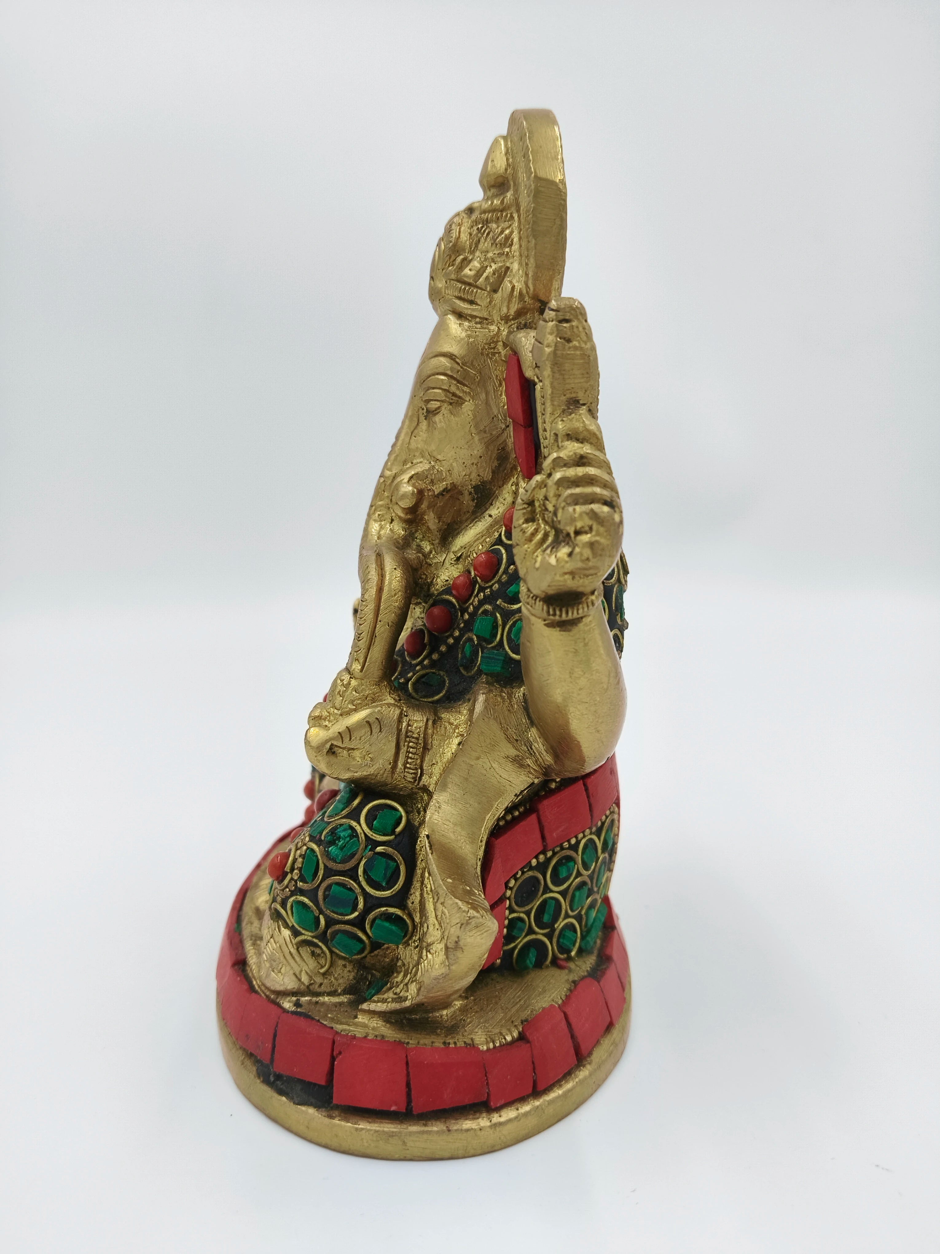 Side view of medium brass Ganesh statue with red and green inlay decoration