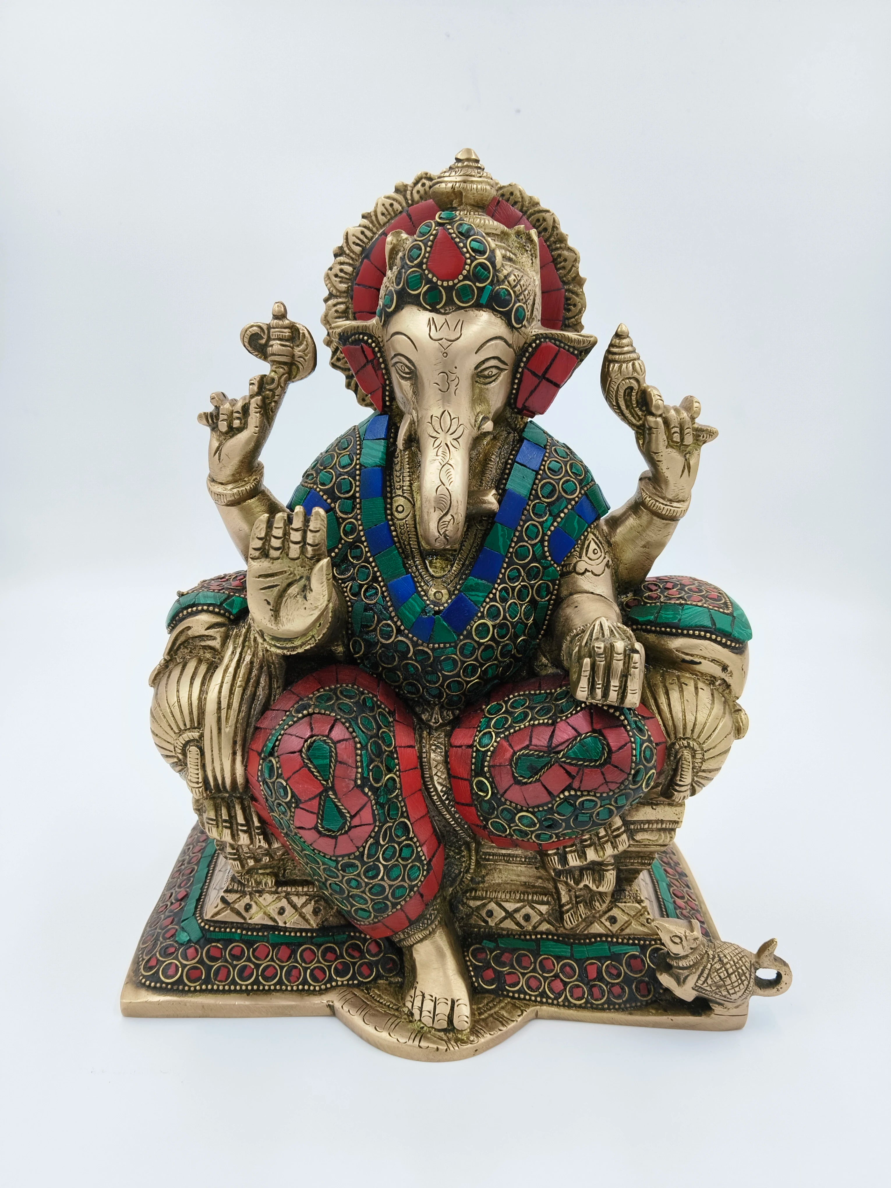 Large brass Ganesh statue with colorful inlay, seated on ornate base