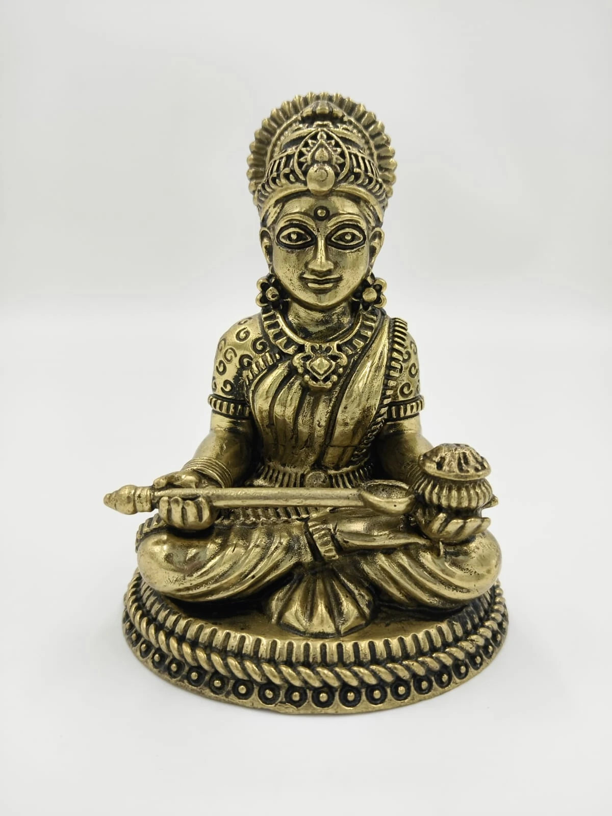 Small brass sculpture of deity Annapoorna seated with a ladle and bowl