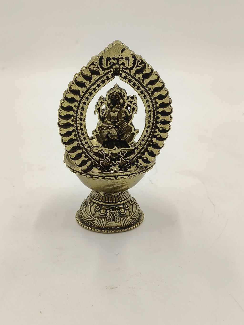 Medium brass Ganesh sculpture with decorative arch and base
