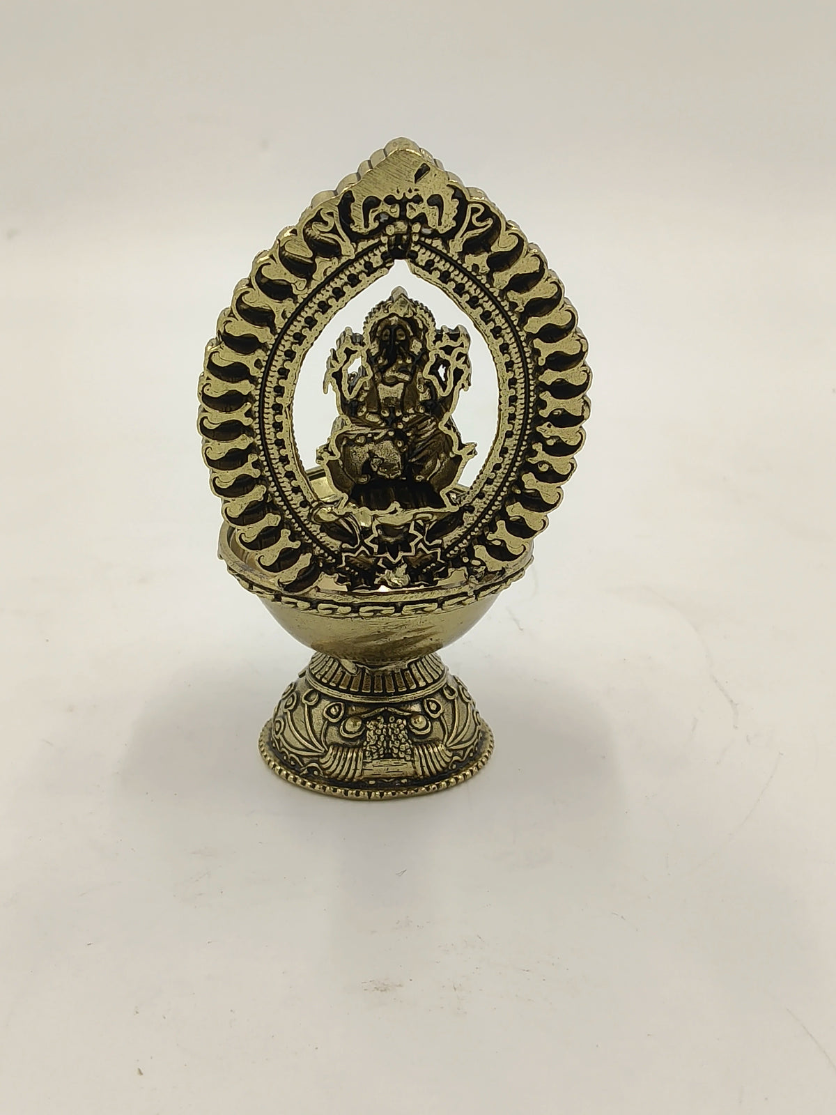 Medium brass Ganesh sculpture with decorative arch and base
