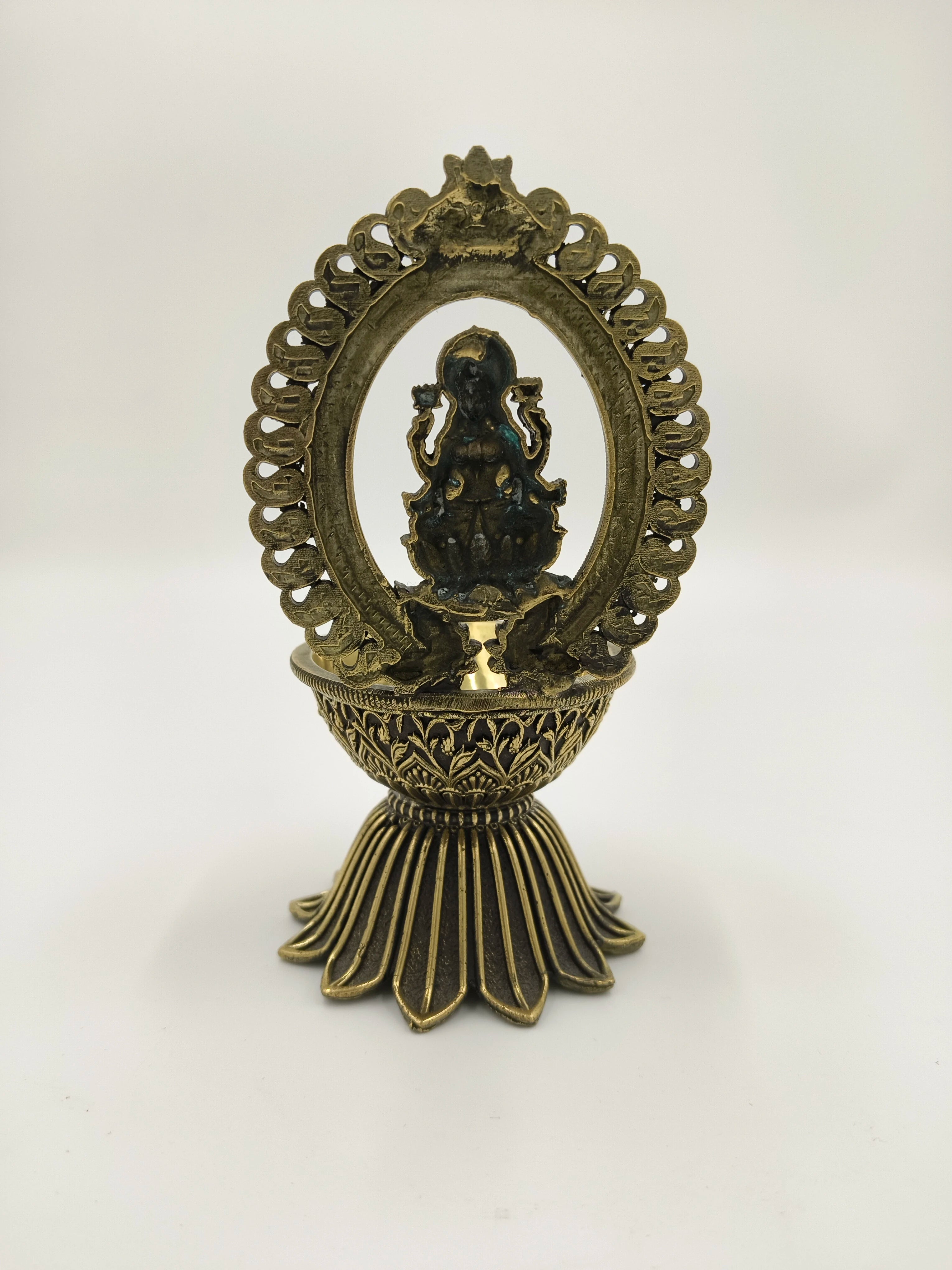 Large brass sculpture of Lakshmi under decorative arch on pedestal base