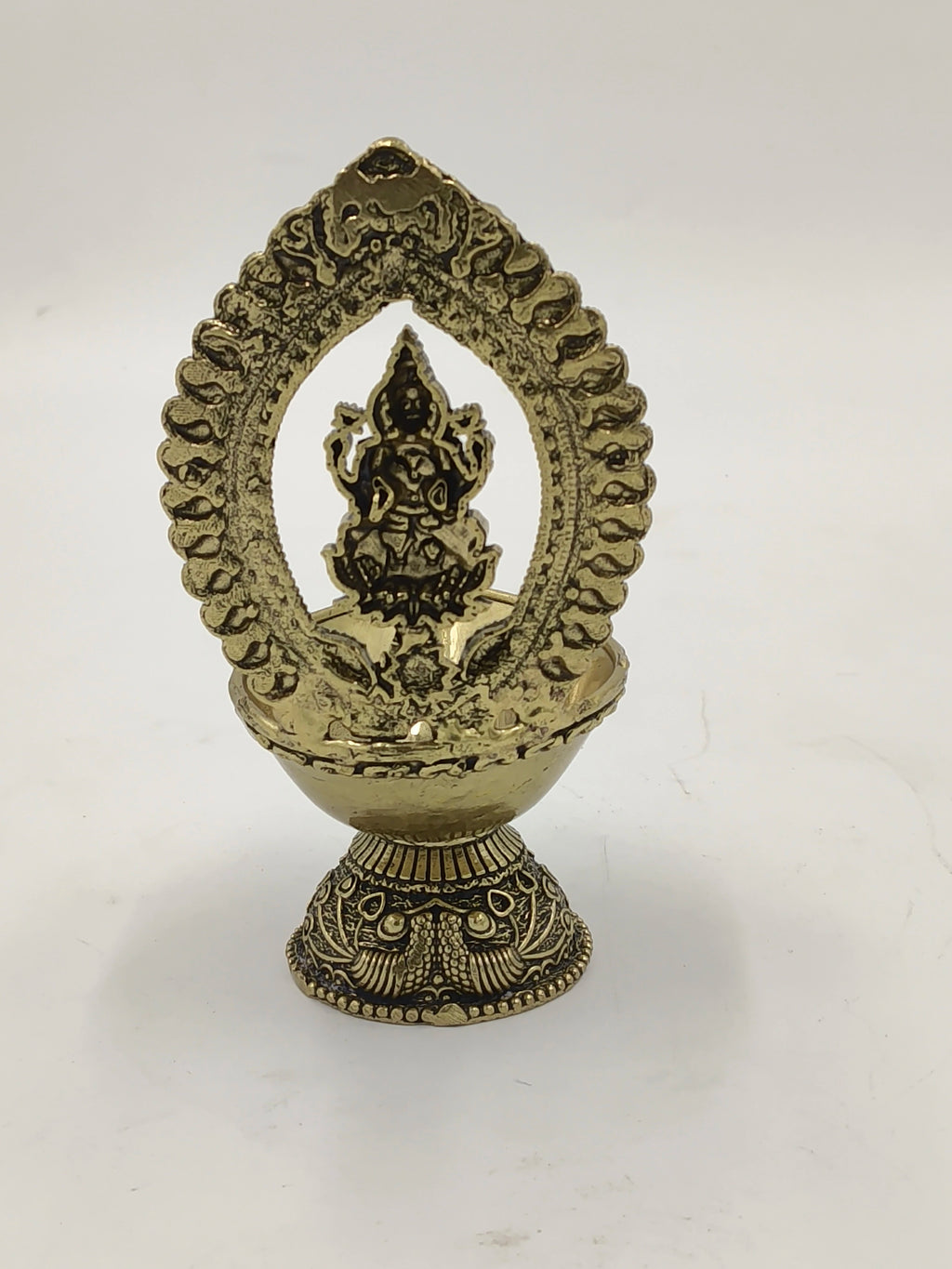 Small brass Lakshmi statue with decorative arch and base