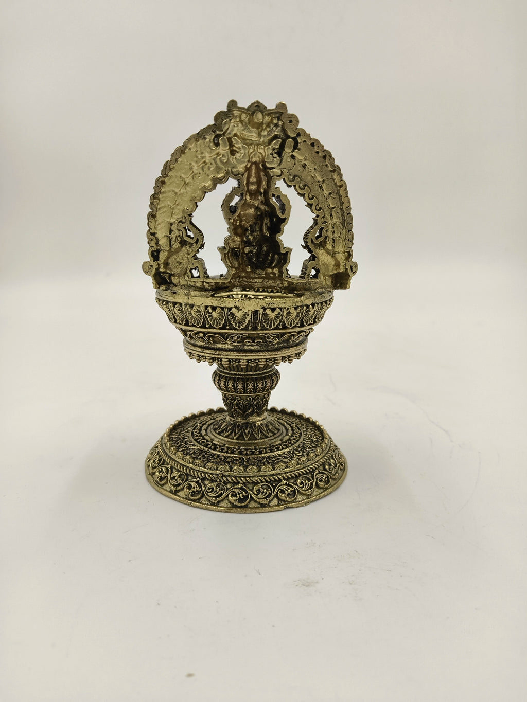 Brass sculpture with decorative arch and pedestal base