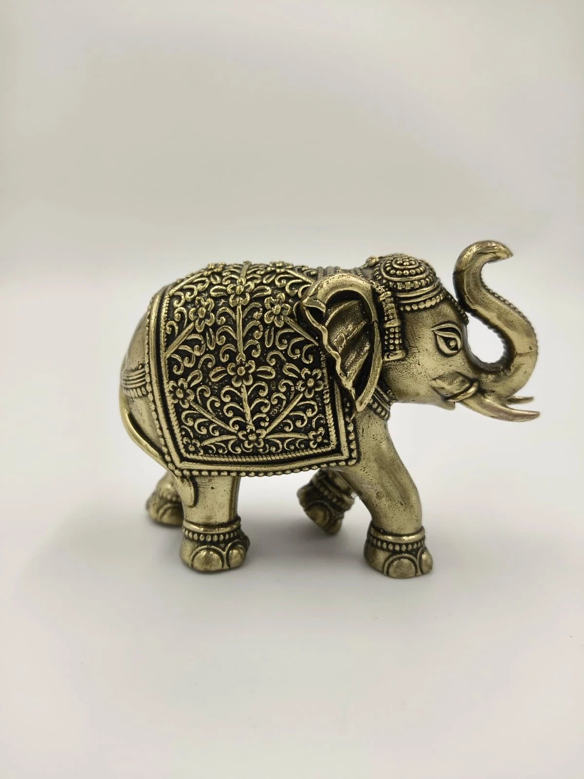 Mini brass elephant sculpture with intricate floral patterns side view