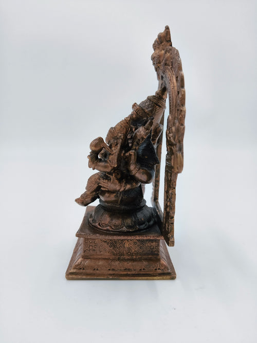 Side view of medium copper Narasimha Swami sculpture with decorative arch