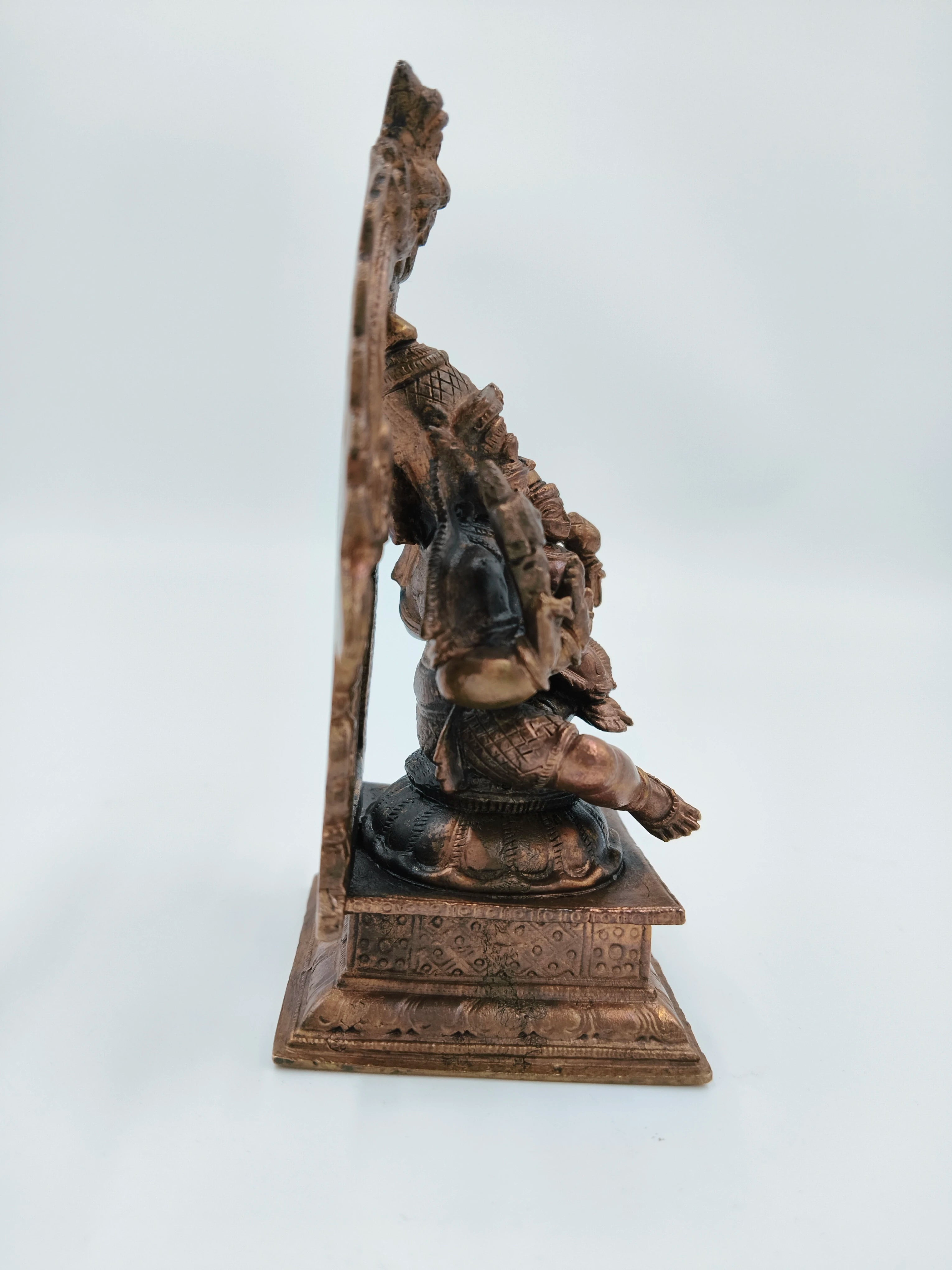 Side view of medium copper Narasimha Swami sculpture on ornate base