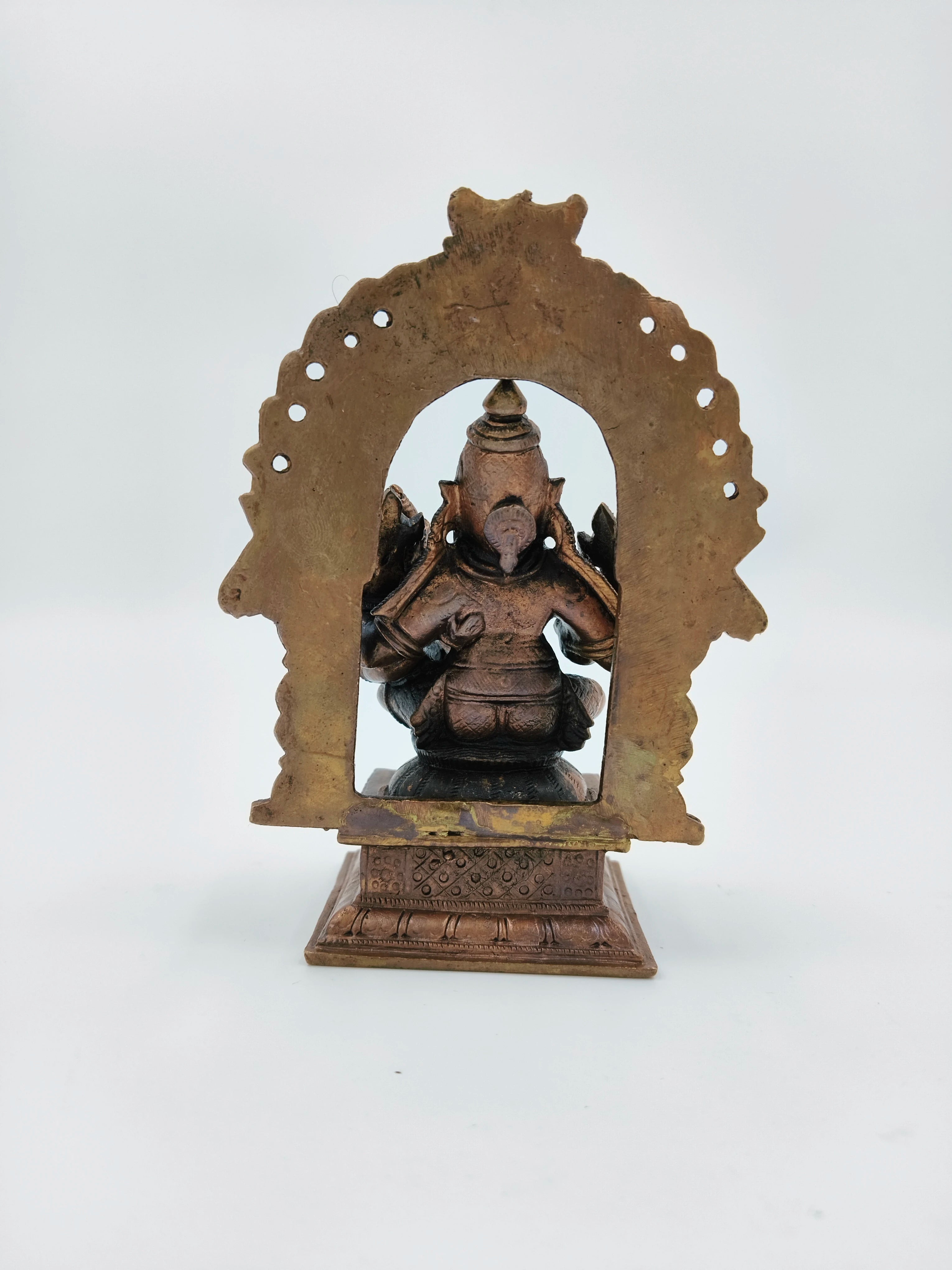 Back view of medium copper Narasimha Swami sculpture with intricate arch frame