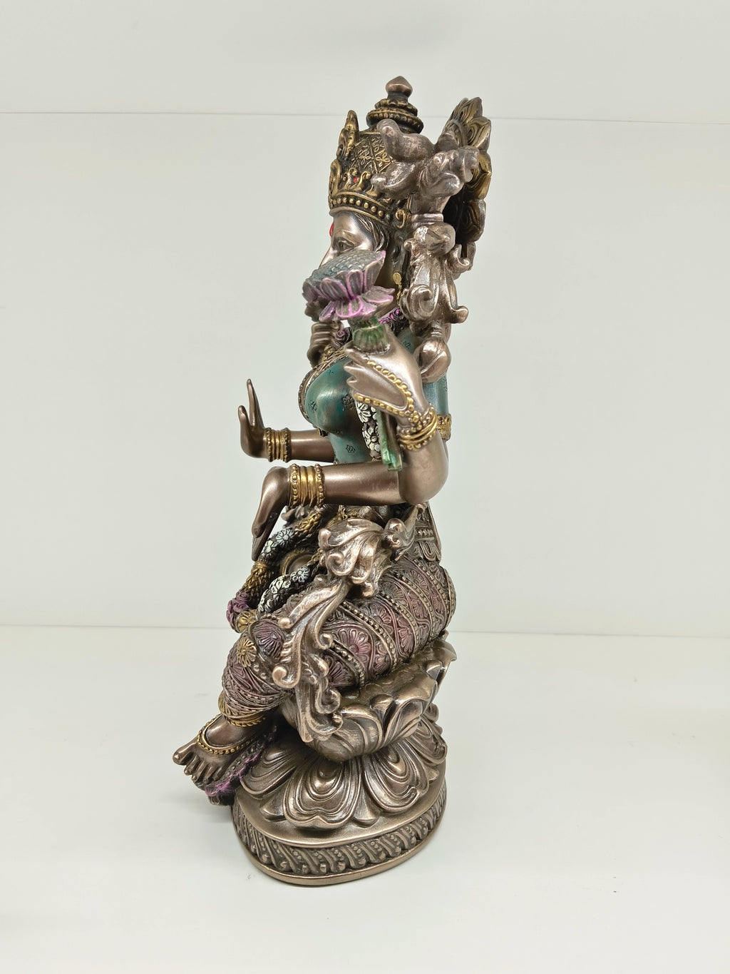 Side view of polyresin statue of Goddess Lakshmi seated on a lotus flower