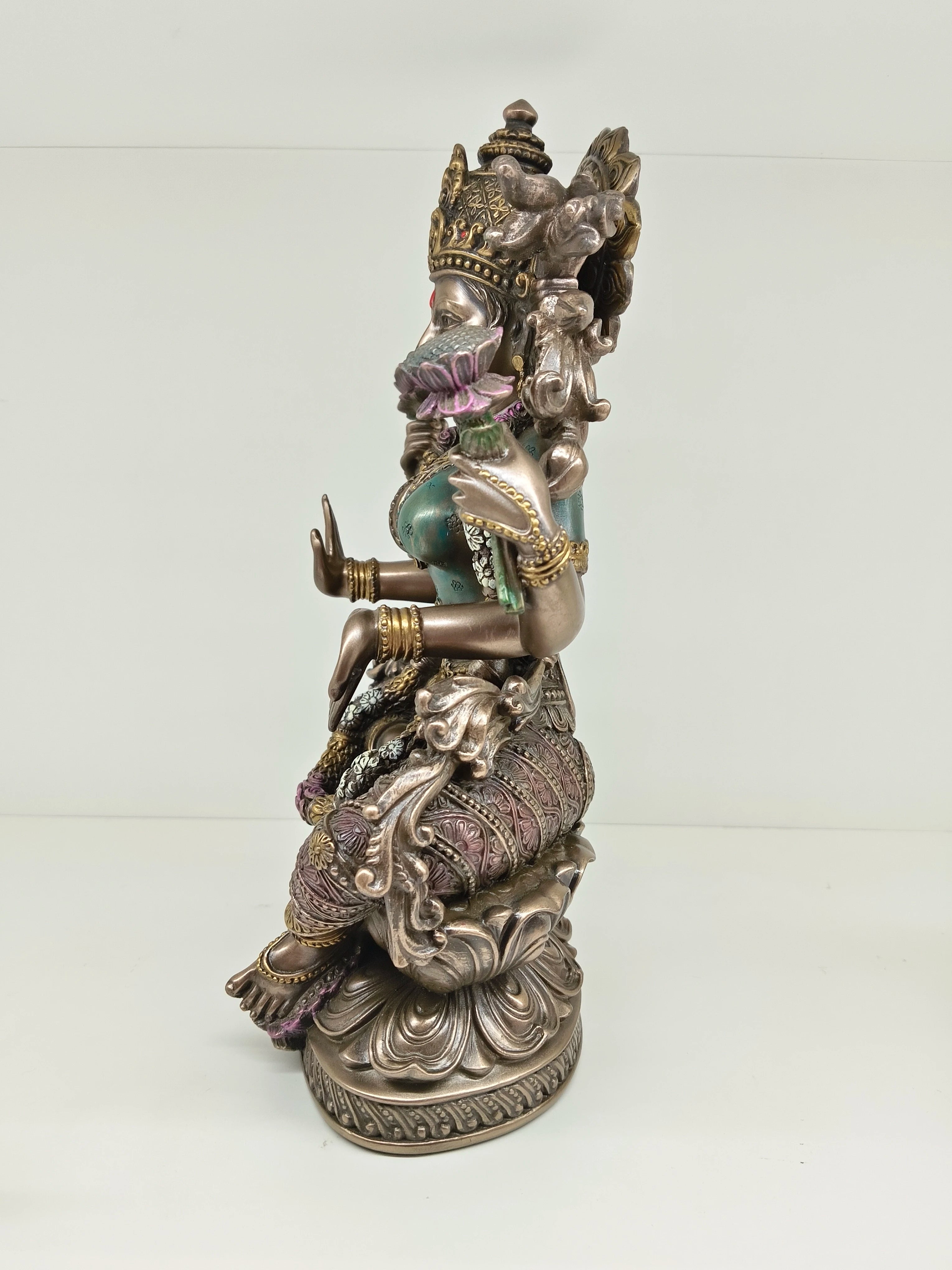 Side view of polyresin statue of Goddess Lakshmi seated on a lotus flower