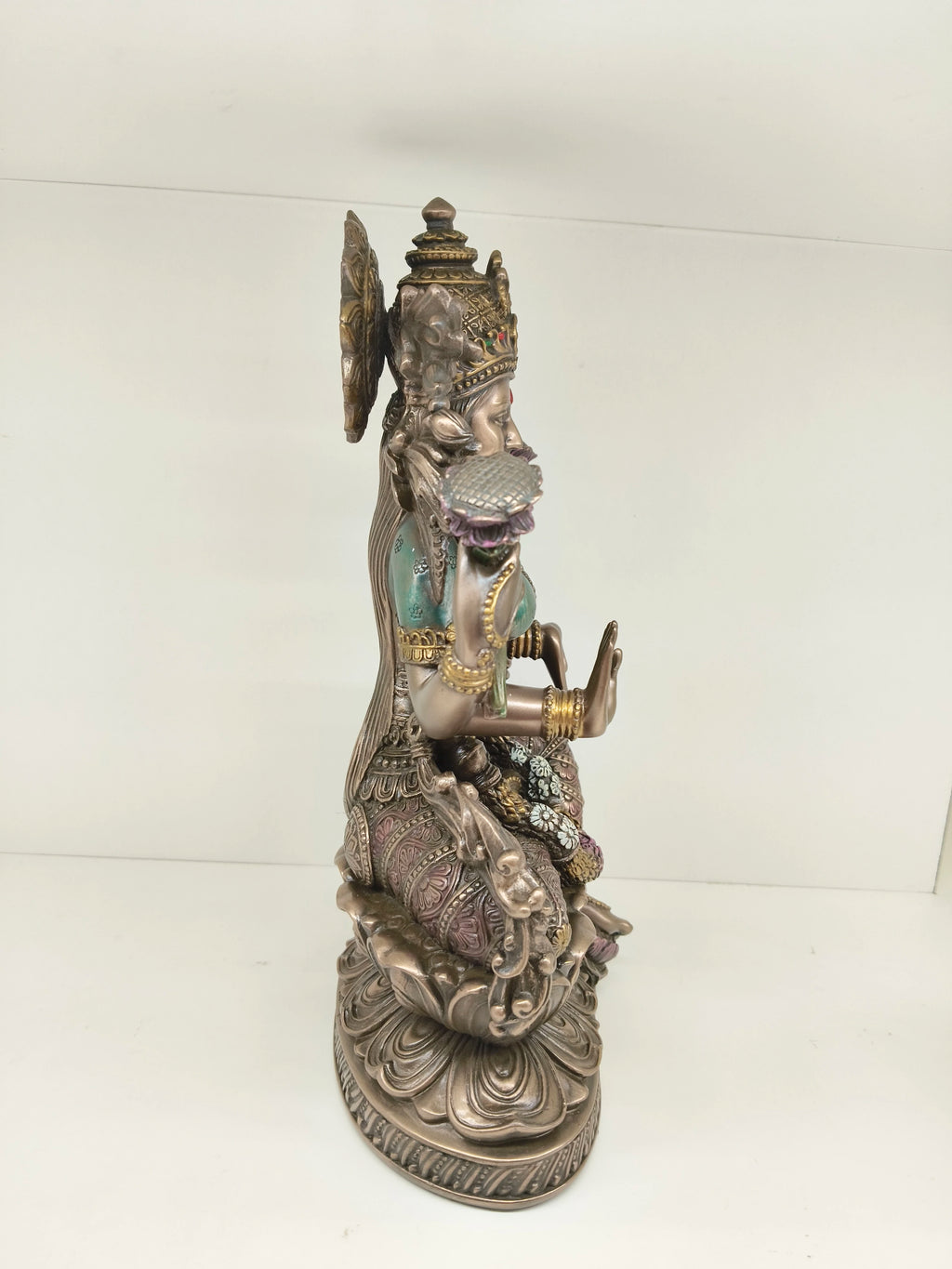 Side view of a large polyresin statue of Goddess Lakshmi seated on a lotus