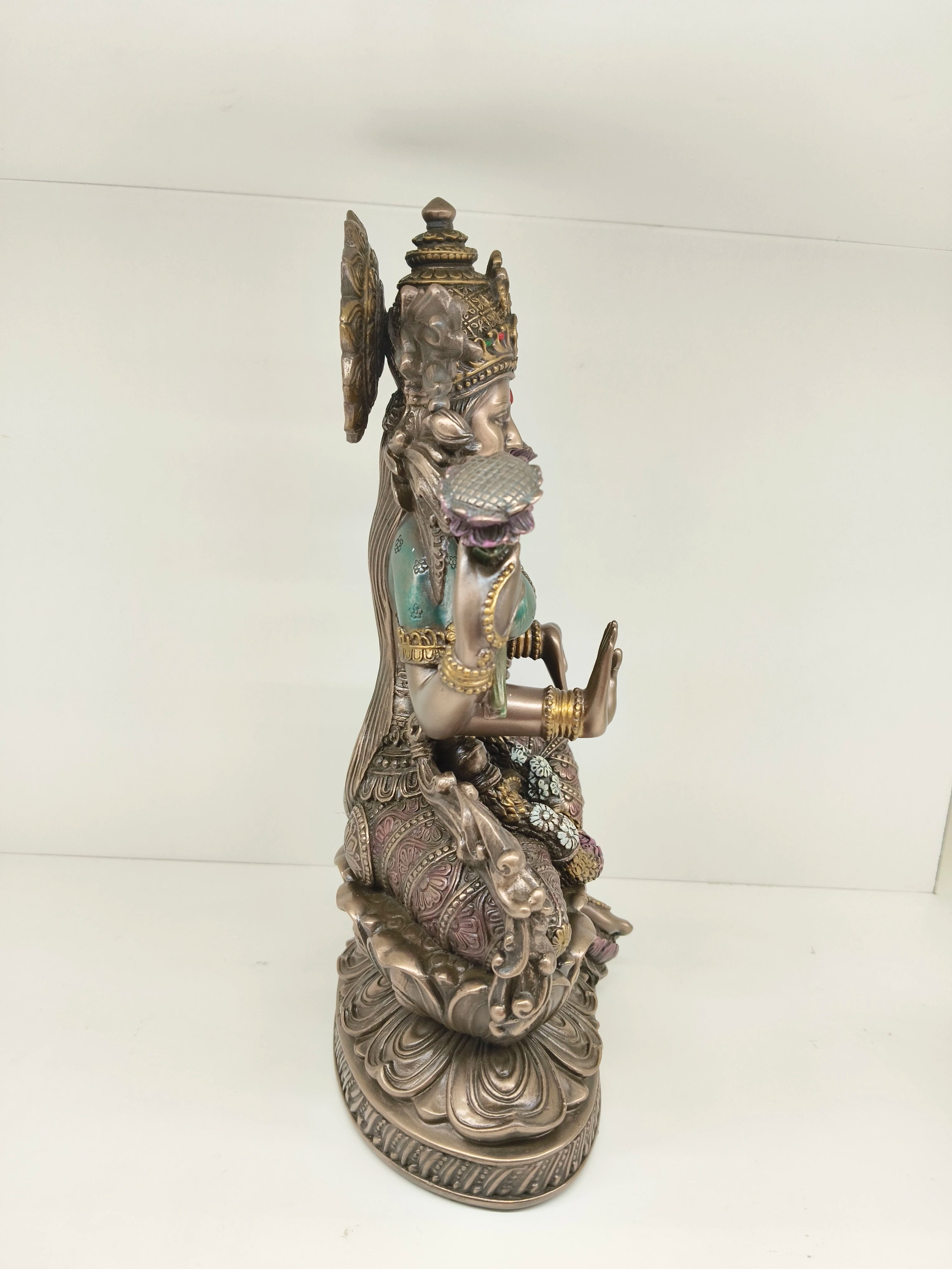 Side view of a large polyresin statue of Goddess Lakshmi seated on a lotus