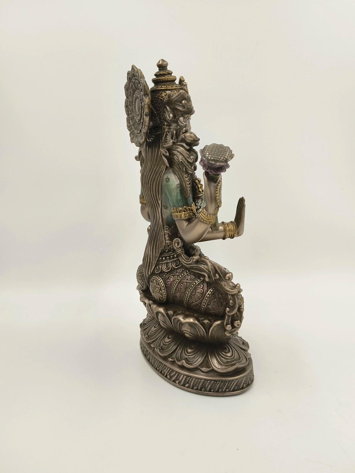Side view of a large polyresin statue of Goddess Lakshmi seated on a lotus