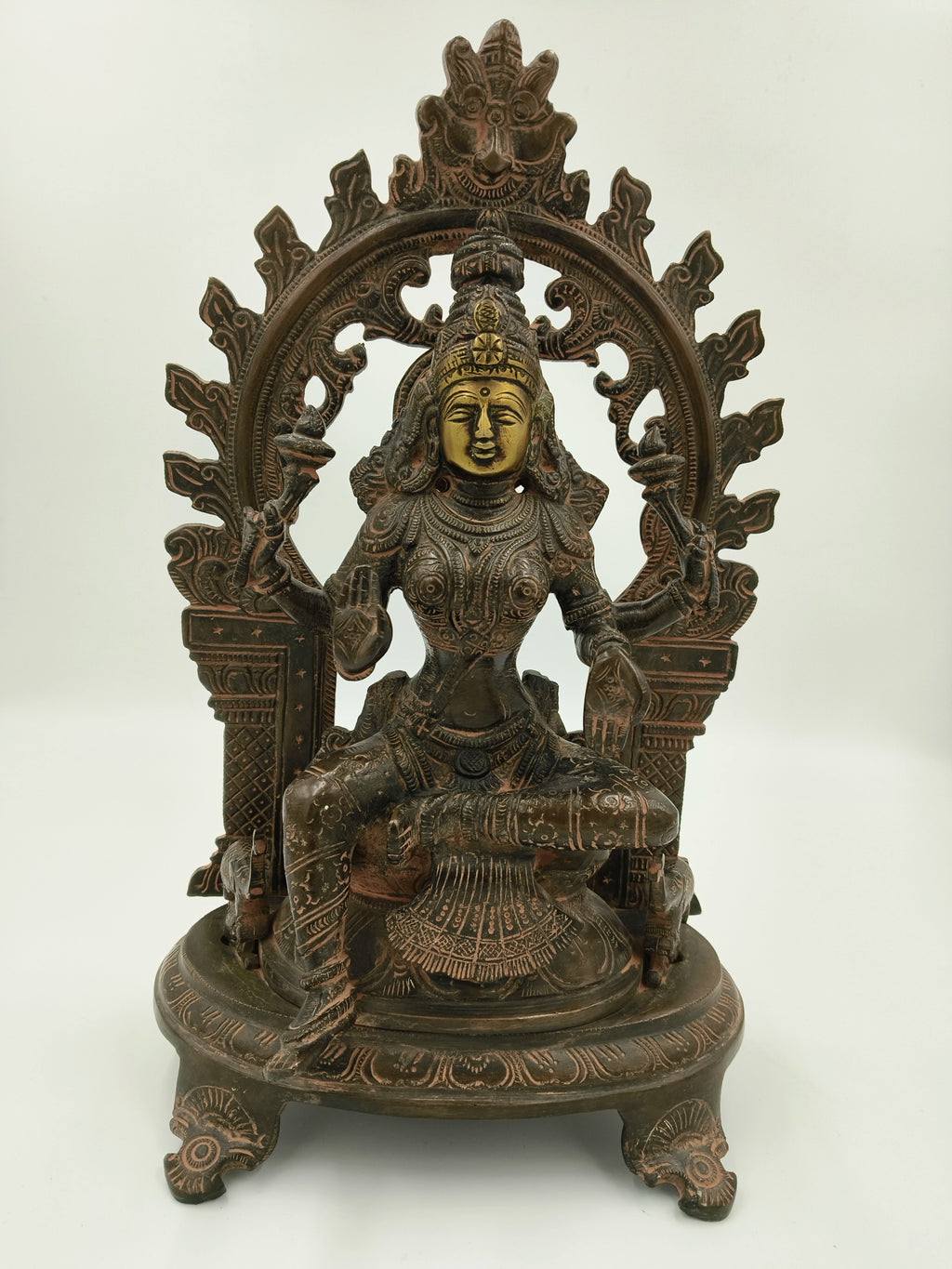 Large brass sculpture of goddess Lakshmi seated under ornate arch