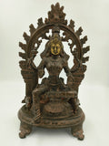 Large brass sculpture of goddess Lakshmi seated under ornate arch