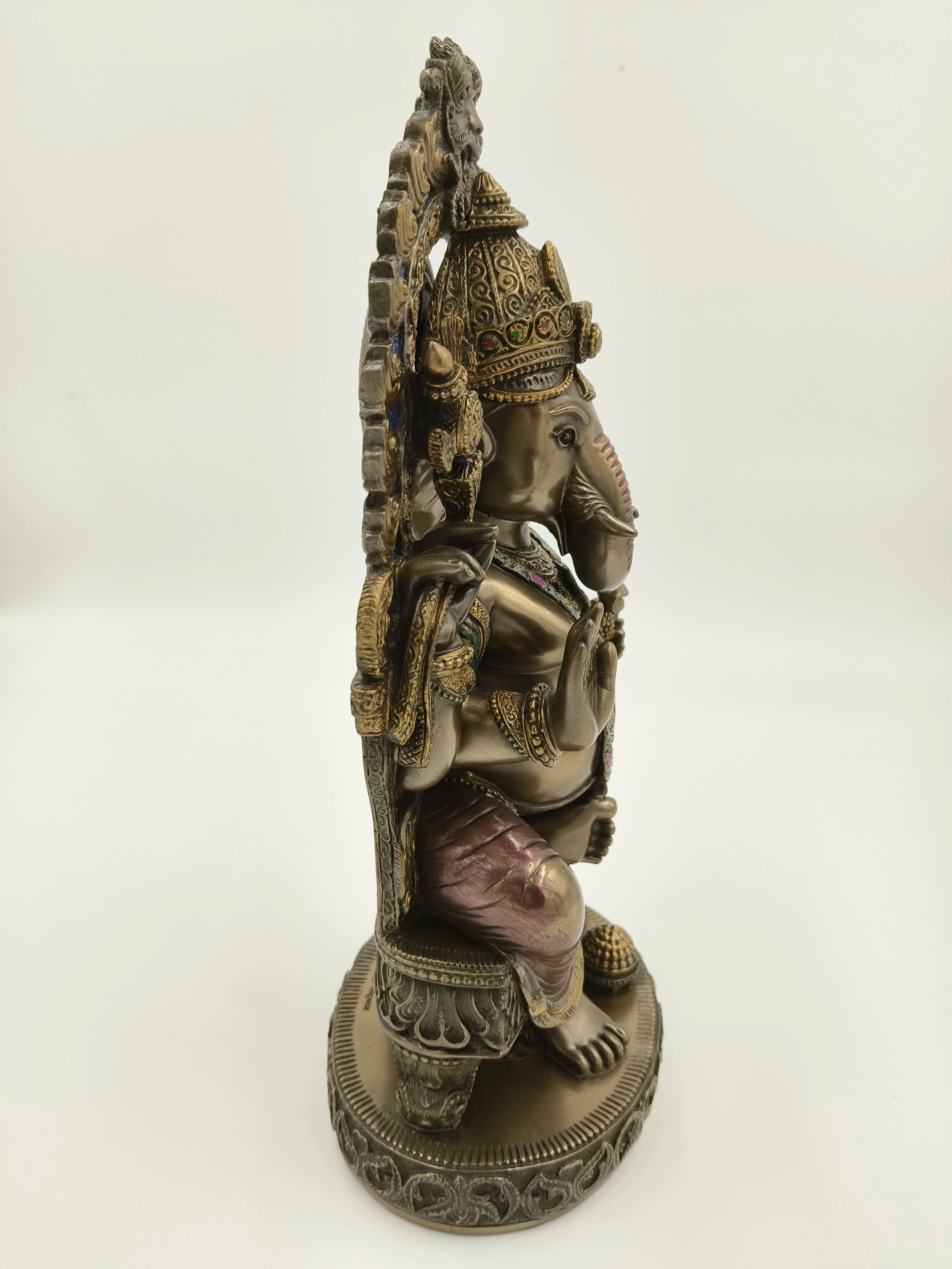 Side view of large polyresin Ganesh sculpture seated on decorated throne