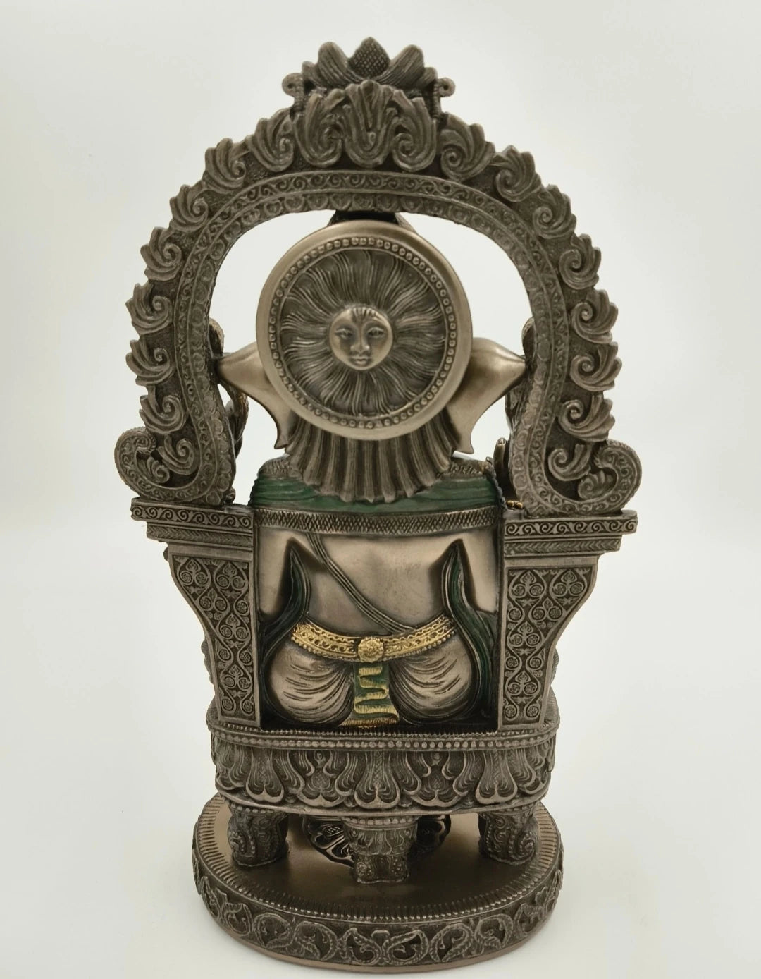 Back view of ornate metal Ganesh statue with detailed carvings and sun motif