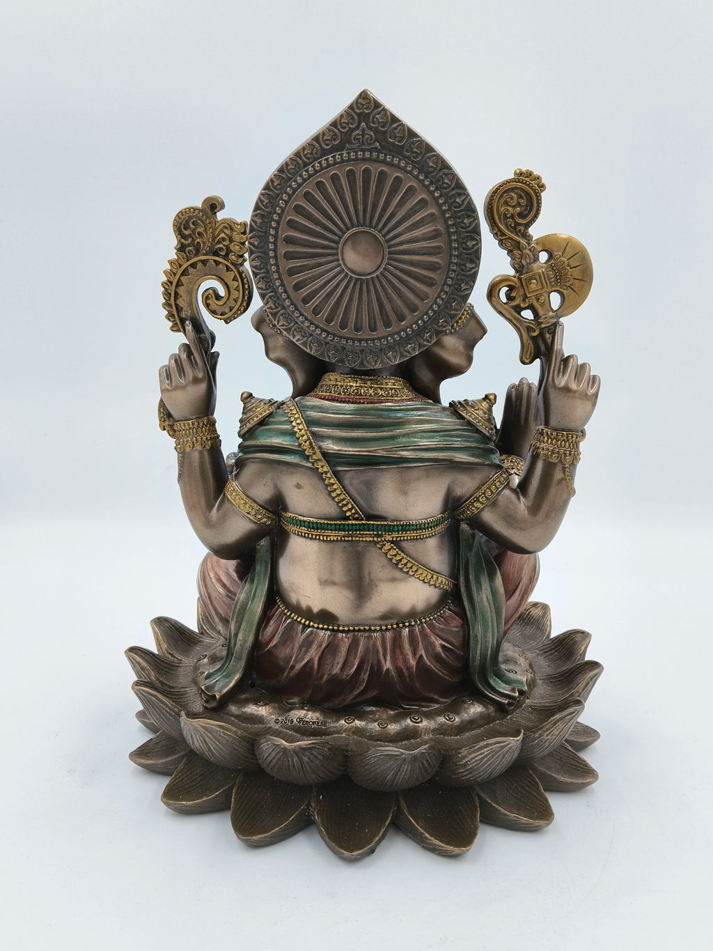 Back view of polyresin Ganesh sculpture seated on lotus with detailed adornments