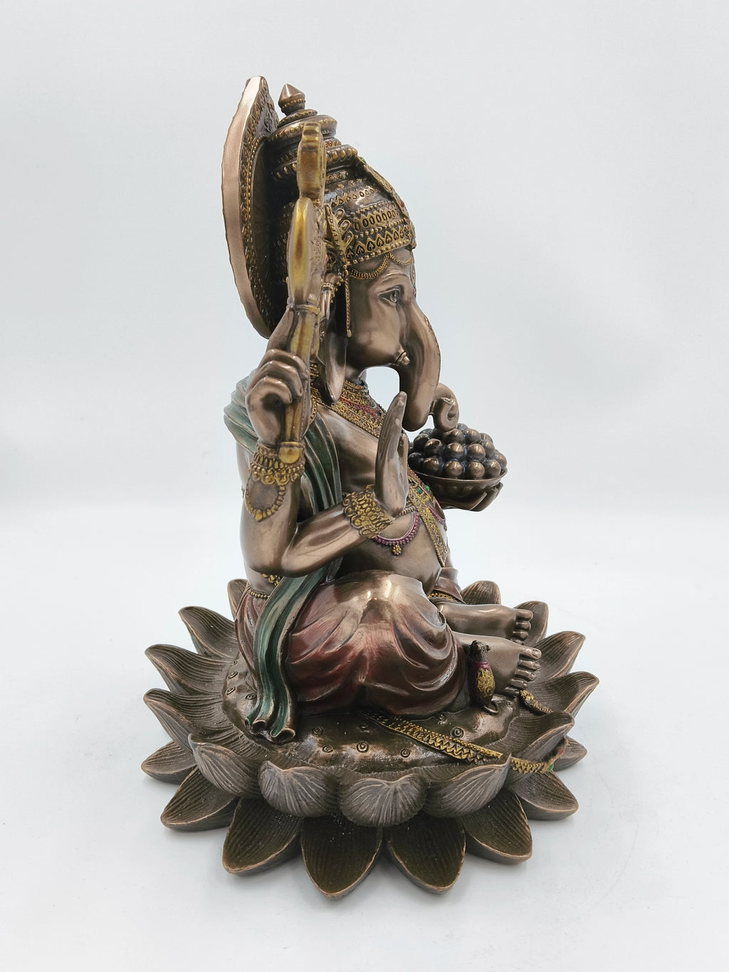 Side view of large polyresin Ganesh sculpture seated on a lotus