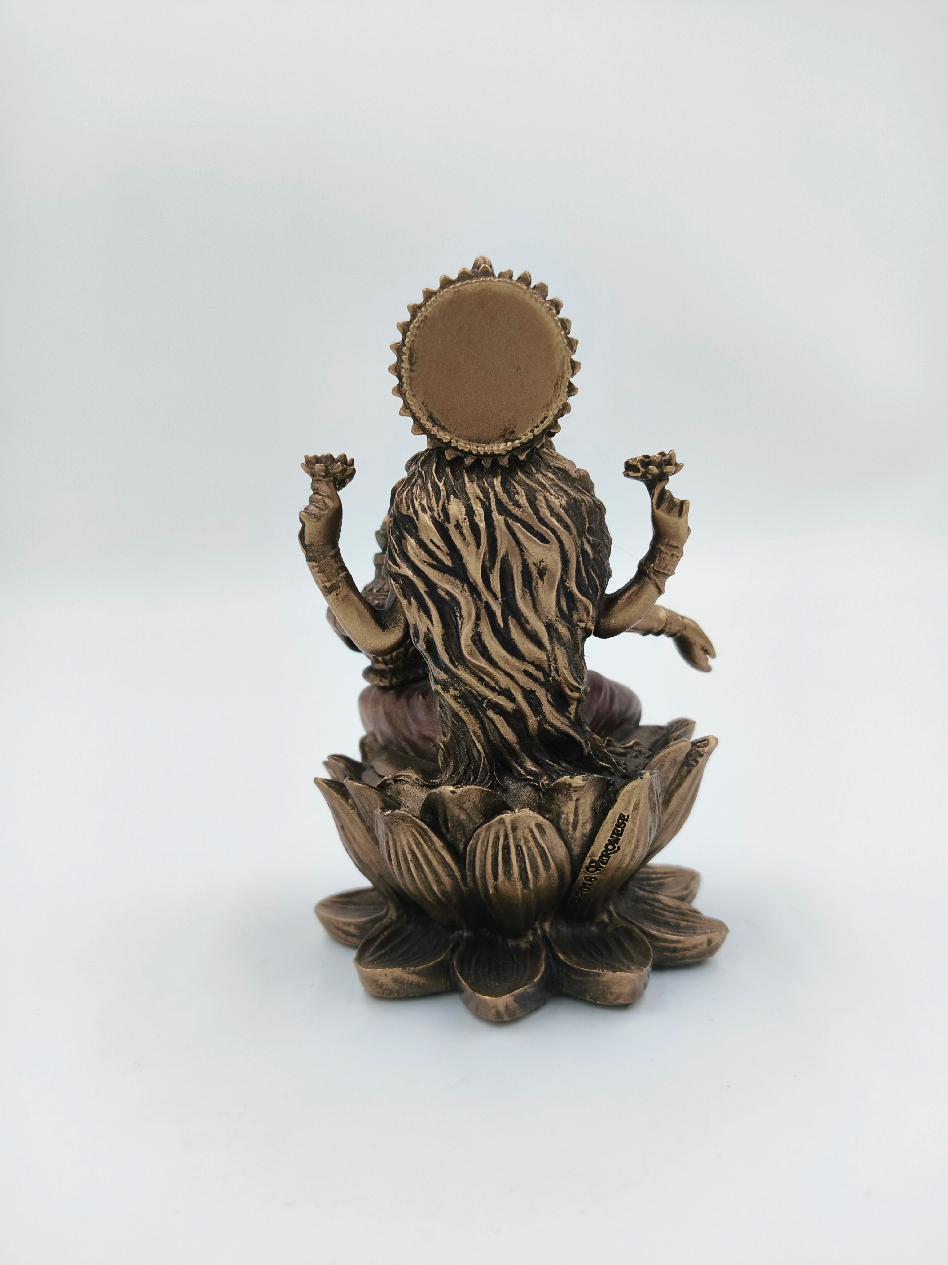Back view of small polyresin Lakshmi statue seated on lotus with decorative details