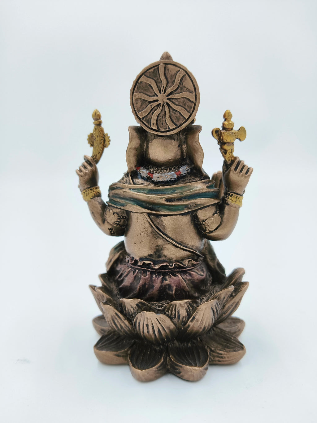 Back view of small polyresin Ganesh statue seated on a lotus flower