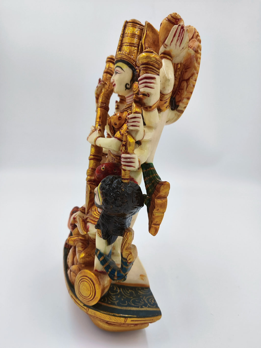 Side view of a large polyresin statue of goddess Durga with intricate gold and colored detailing