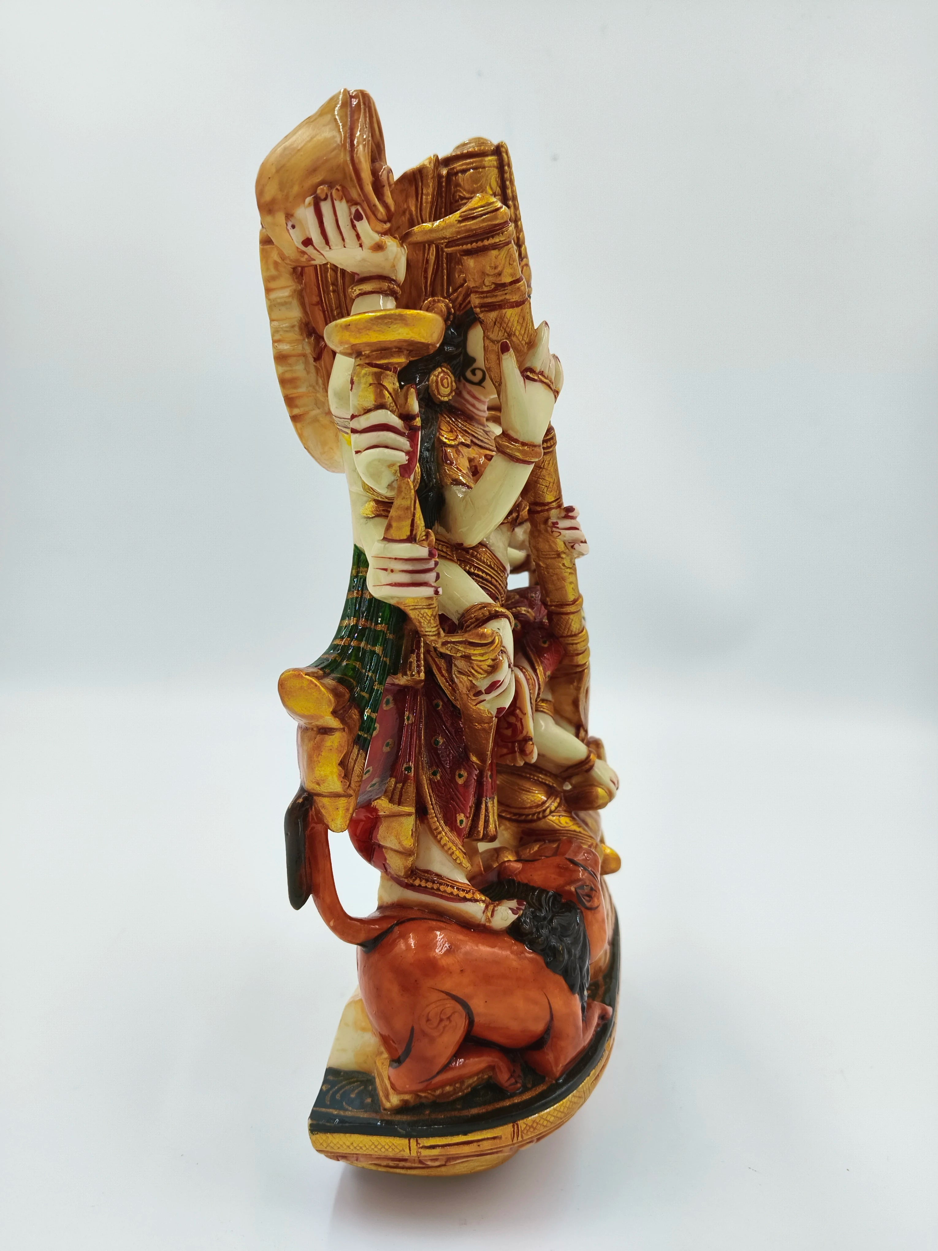 Side view of polyresin statue depicting goddess Durga with multiple arms on a lion