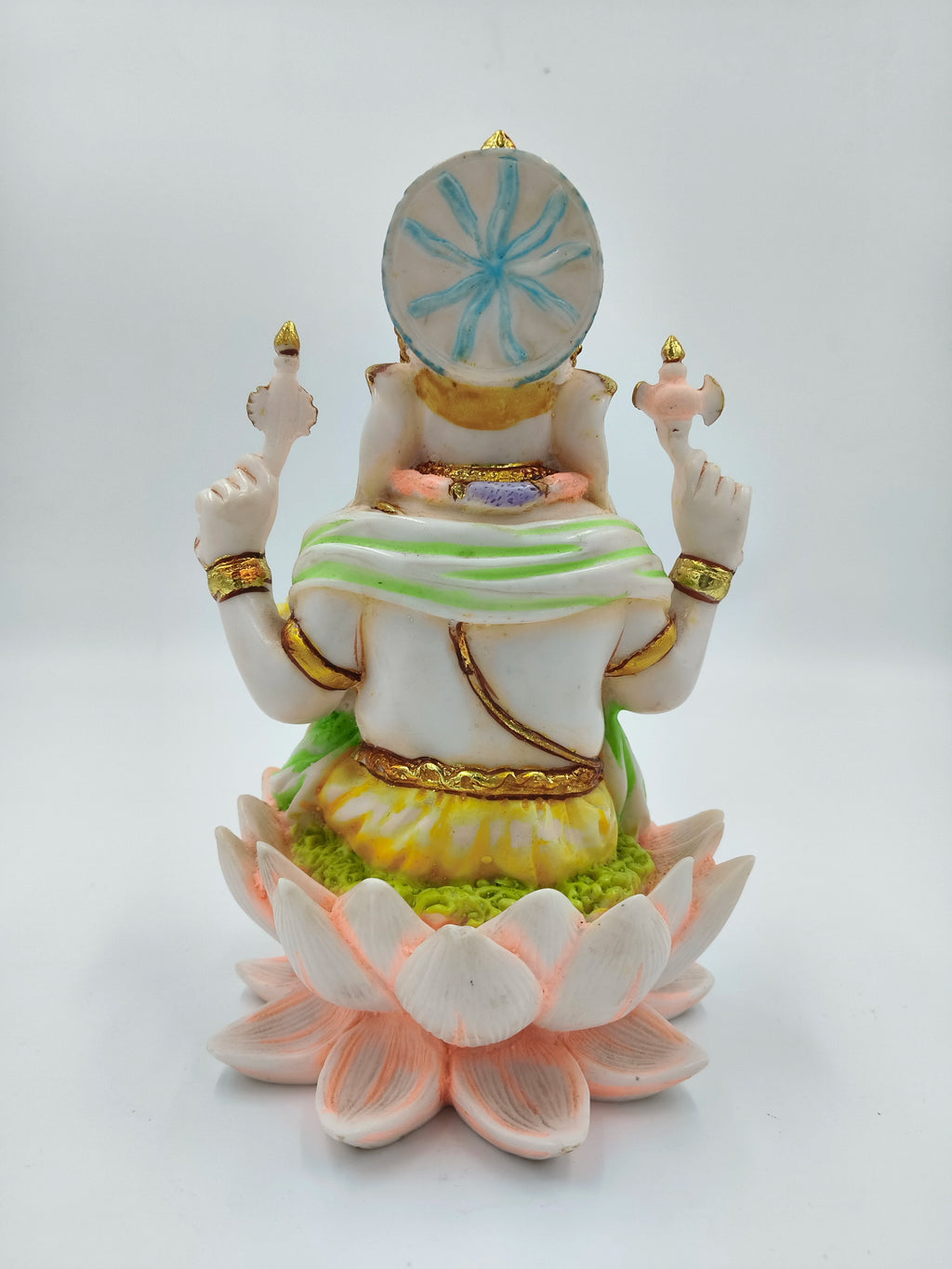 Back view of polyresin Ganesh statue seated on a lotus base with decorative colors