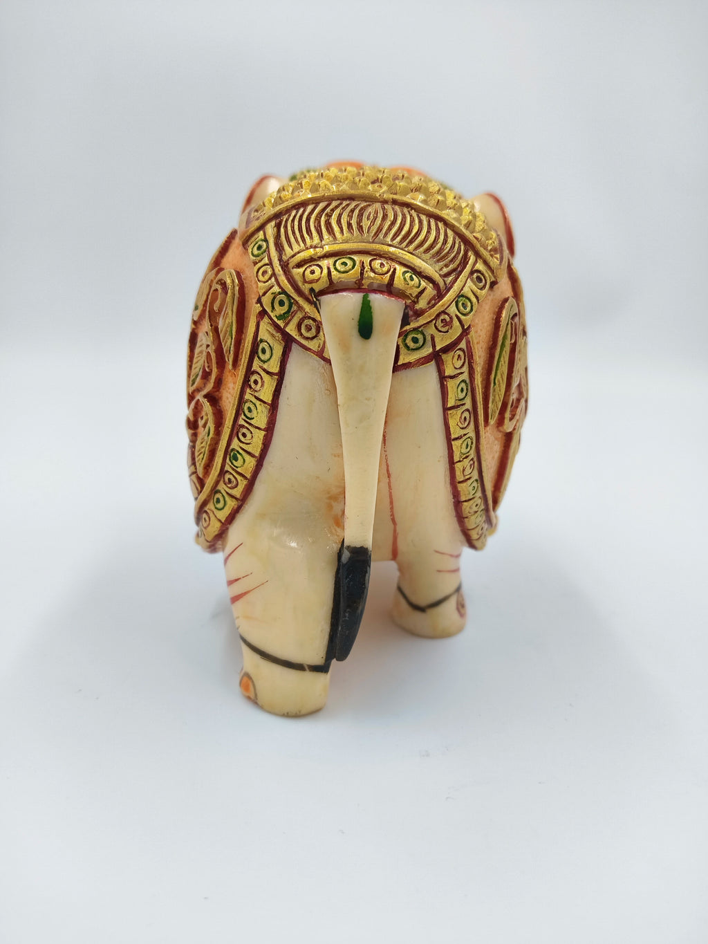 Small polyresin elephant figurine with intricate gold and orange detailing, rear view