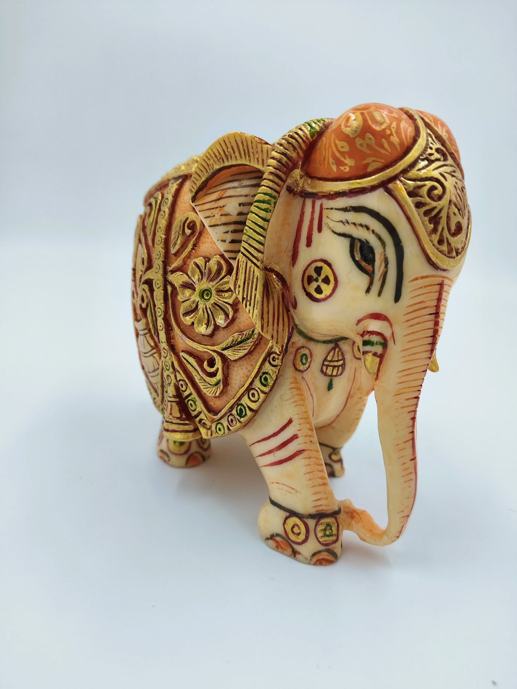 Small polyresin elephant figurine with intricate painted decorations and golden accents