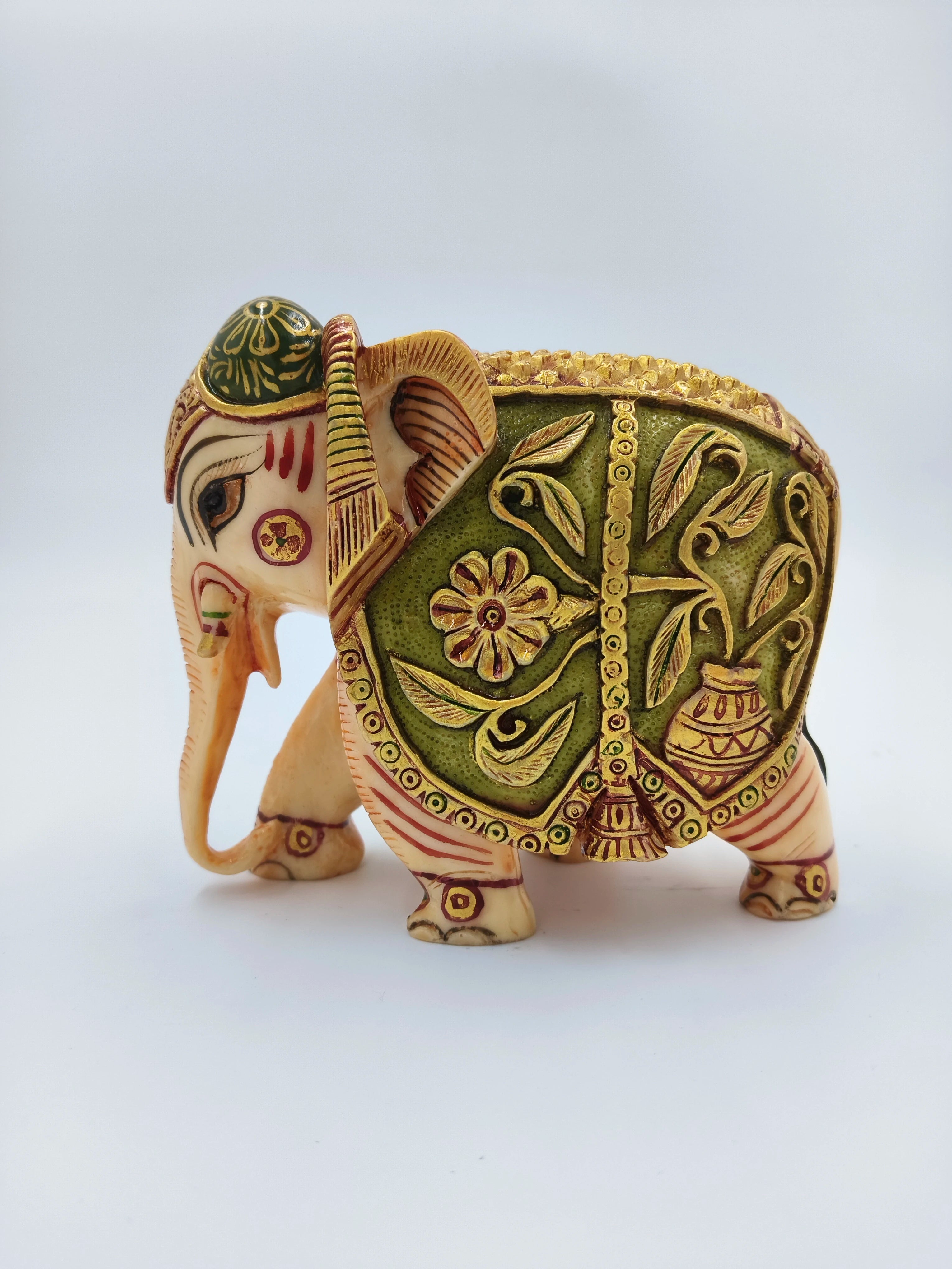 Small polyresin elephant figurine with green and gold decorative patterns side view