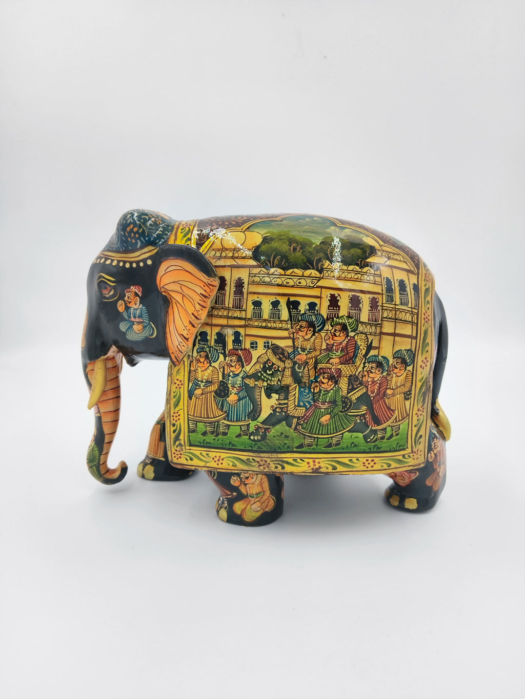 Hand-painted wooden elephant figurine with detailed procession artwork on side