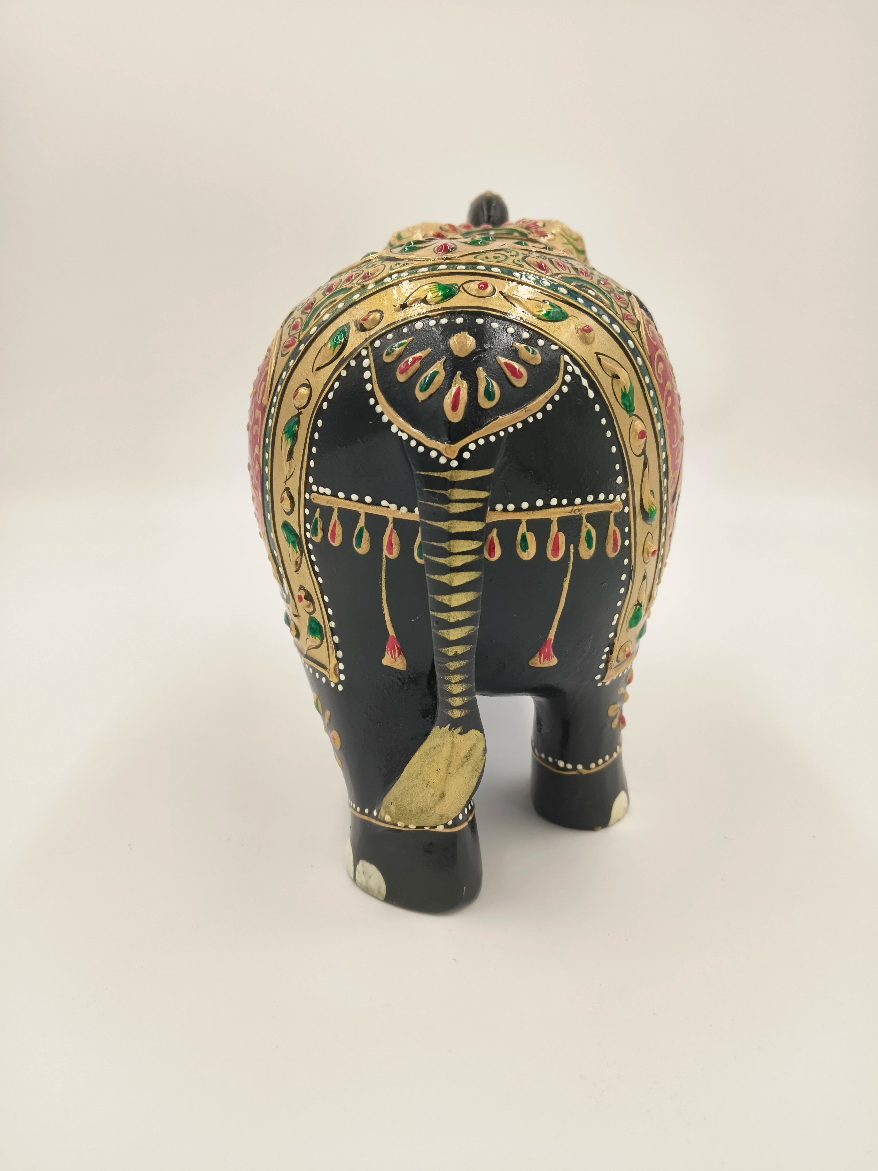 Back view of hand-painted wood elephant sculpture with intricate gold, red, and green designs