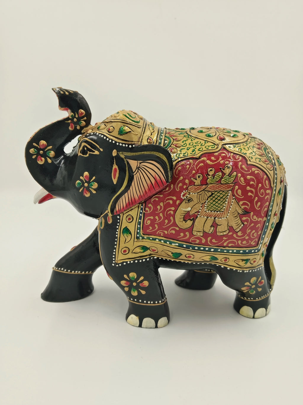 Black wooden elephant sculpture with embossed gold and red painted details