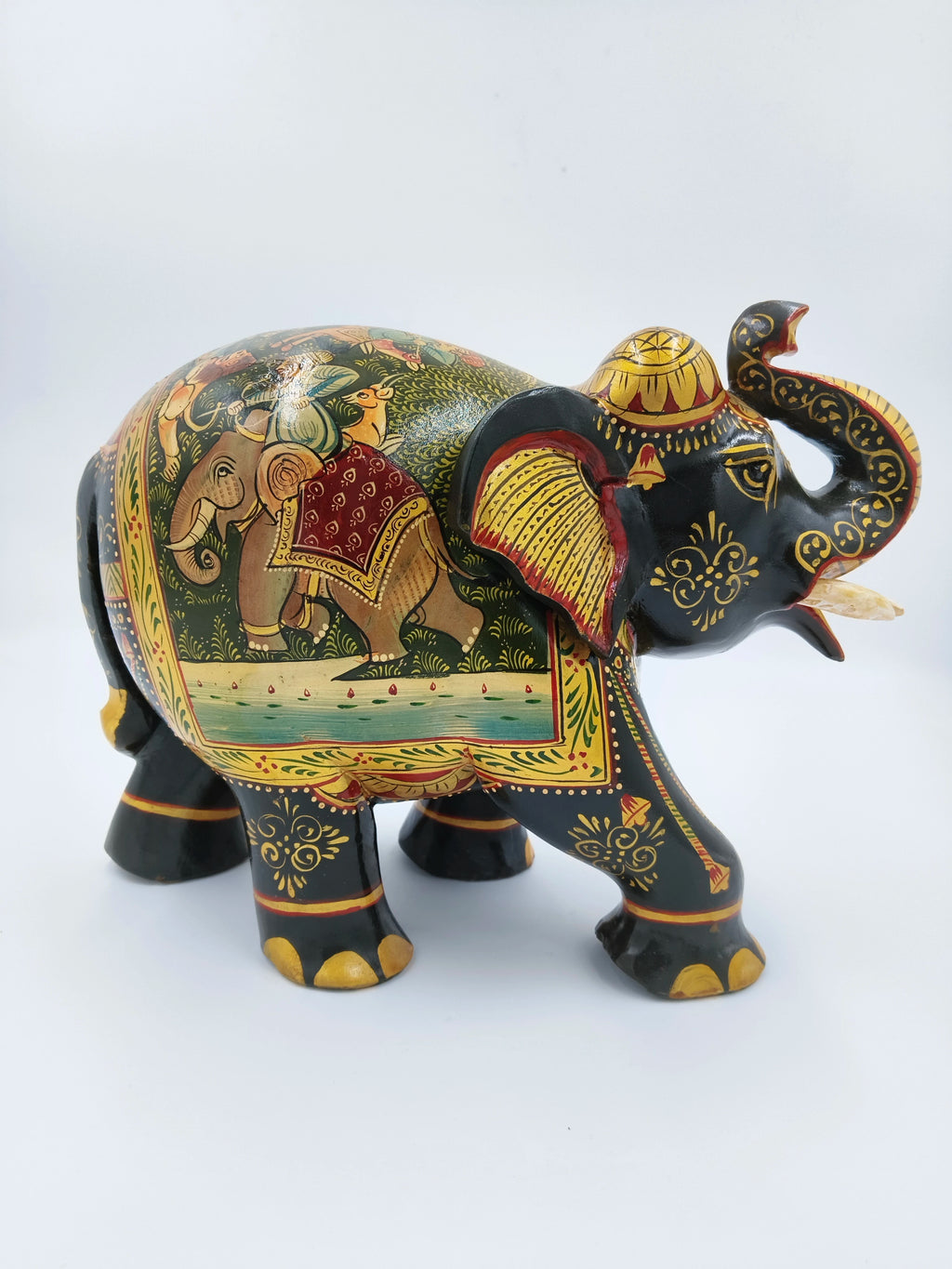 Side view of a large black wooden elephant sculpture with intricate painted designs