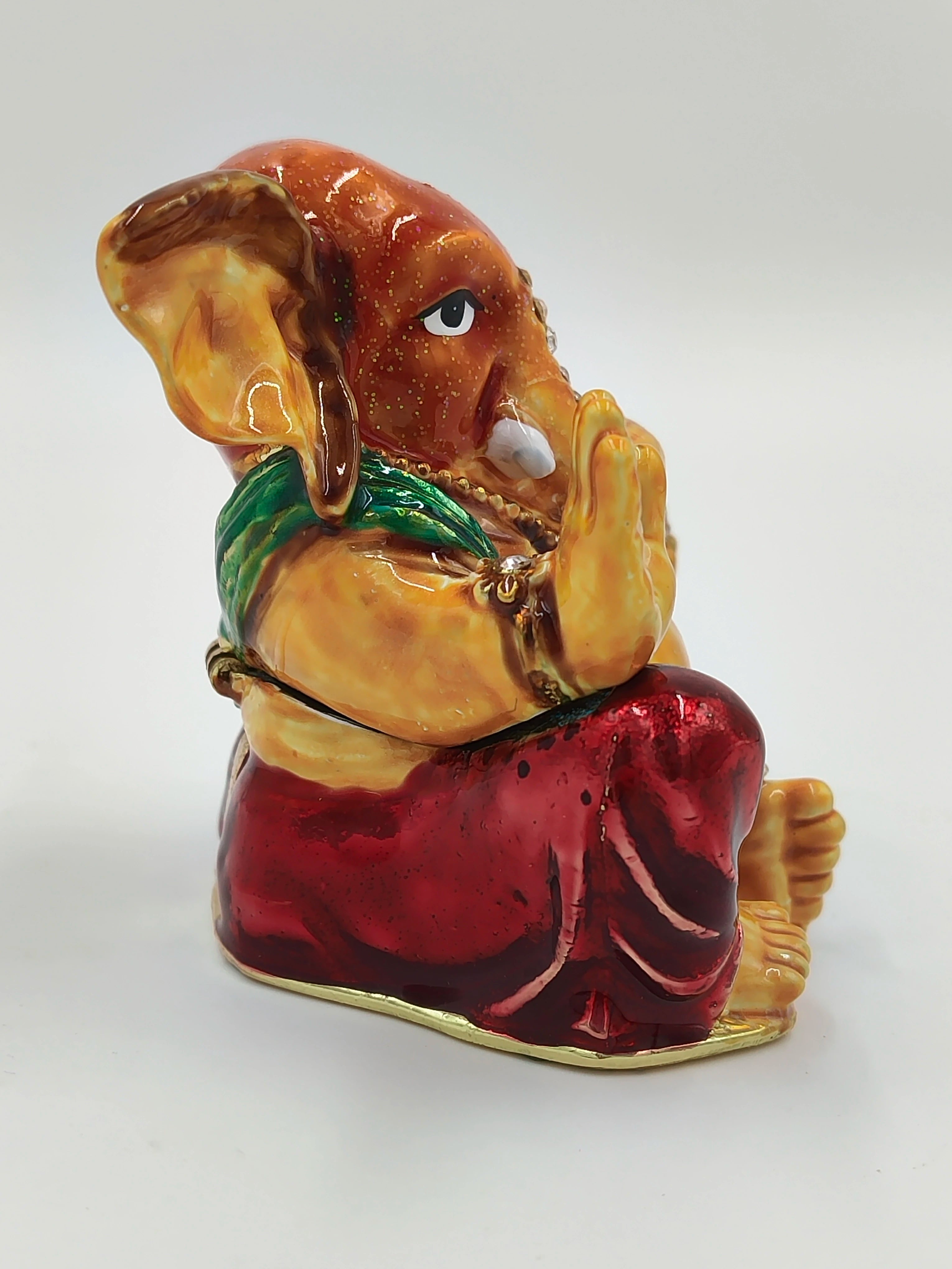 Side view of brass enamel Ganesh statue with artificial stones and red dress